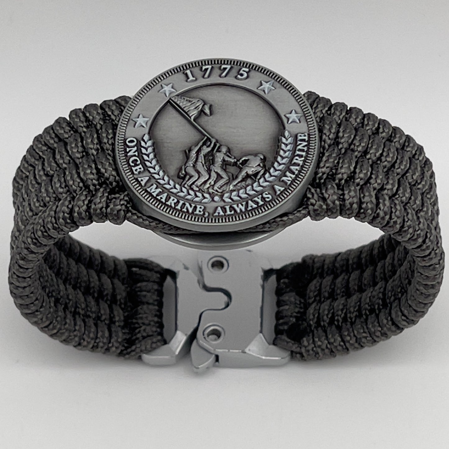 Thin, wide, flexible and comfortable braided United States Marine Corps Iwo Jima bracelet featuring an antique silver plated Iwo Jima flag raising medallion, a silver Cobra style tactical buckle and woven with gray Type-1 paracord.