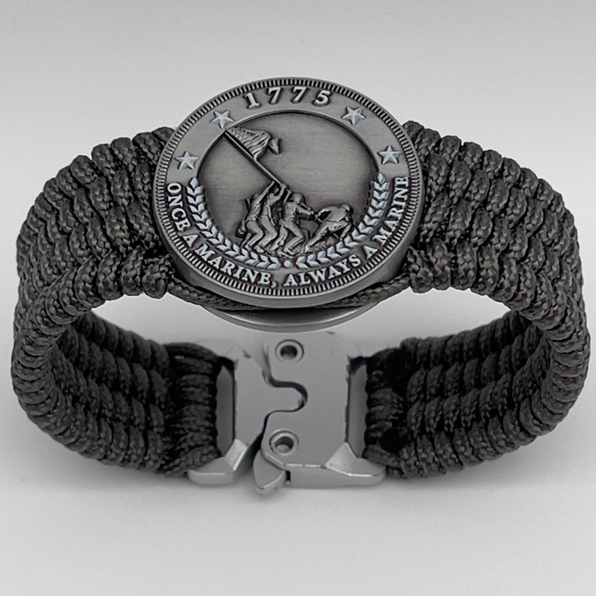 Thin, wide, flexible and comfortable braided United States Marine Corps Iwo Jima bracelet featuring an antique silver plated Iwo Jima flag raising medallion, a silver Cobra style tactical buckle and woven with gray Type-1 paracord.