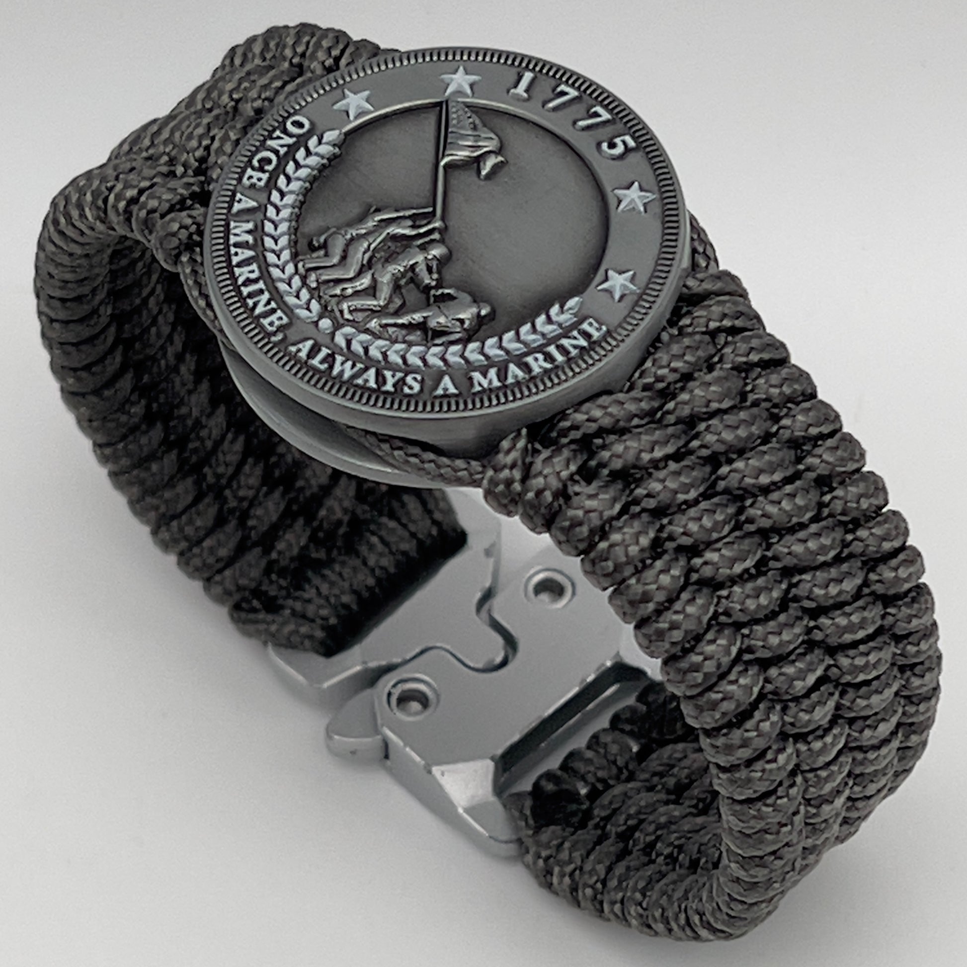 Thin, wide, flexible and comfortable braided United States Marine Corps Iwo Jima bracelet featuring an antique silver plated Iwo Jima flag raising medallion, a silver Cobra style tactical buckle and woven with gray Type-1 paracord.