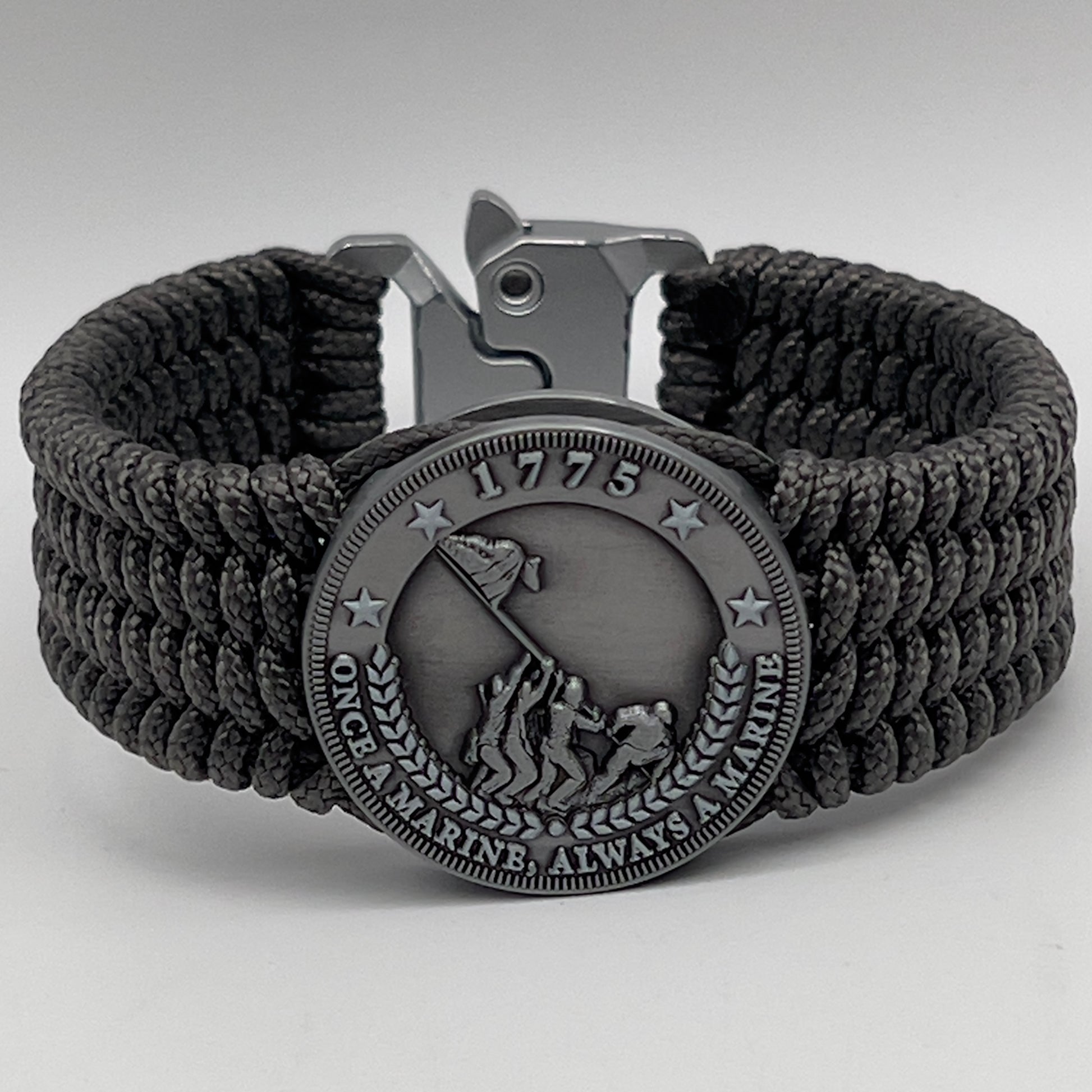 Thin, wide, flexible and comfortable braided United States Marine Corps Iwo Jima bracelet featuring an antique silver plated Iwo Jima flag raising medallion, a silver Cobra style tactical buckle and woven with gray Type-1 paracord.