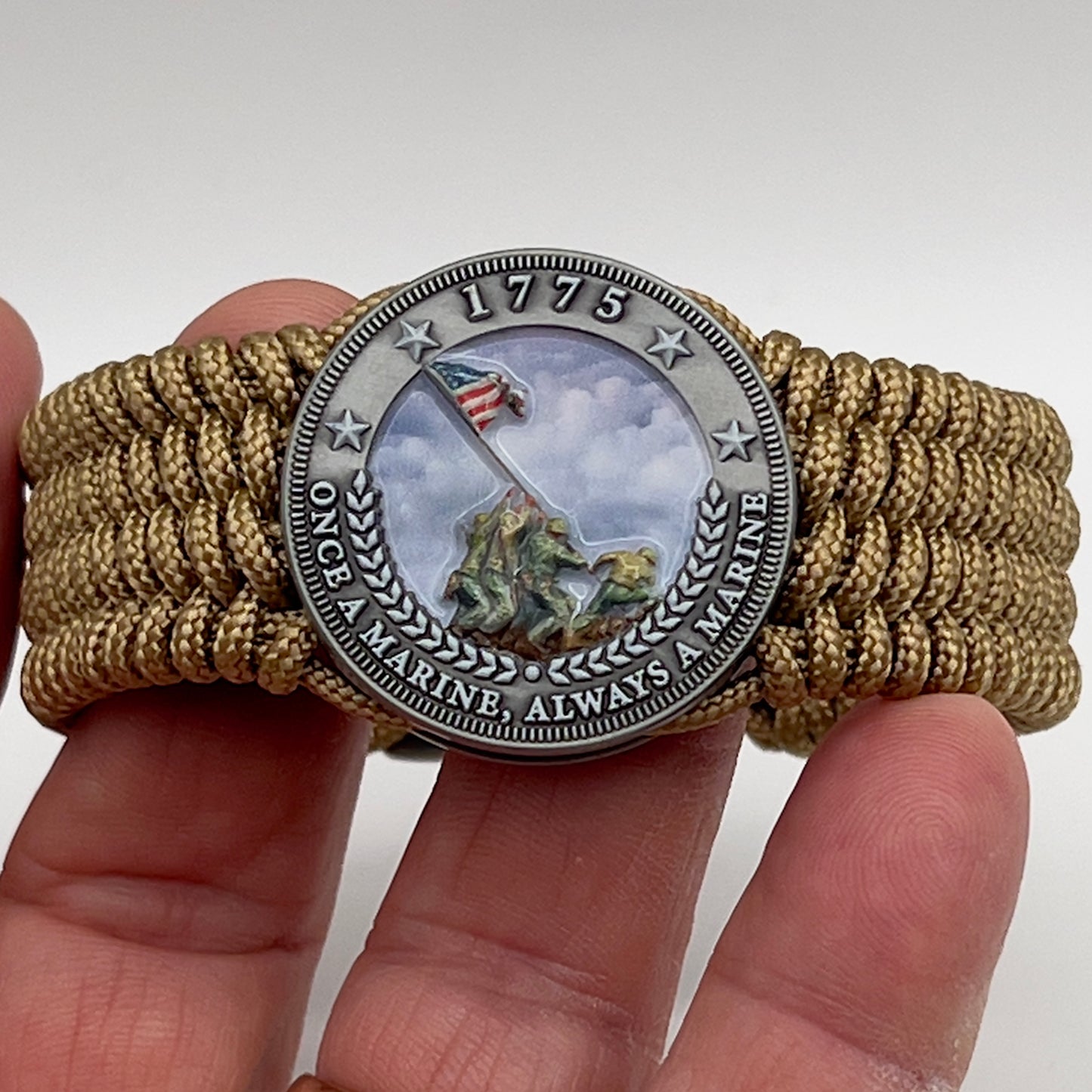 Thin, wide, flexible and comfortable braided United States Marine Corps Iwo Jima bracelet featuring an antique silver plated Iwo Jima flag raising medallion, a gold Cobra style tactical buckle and woven with gold Type-1 paracord.