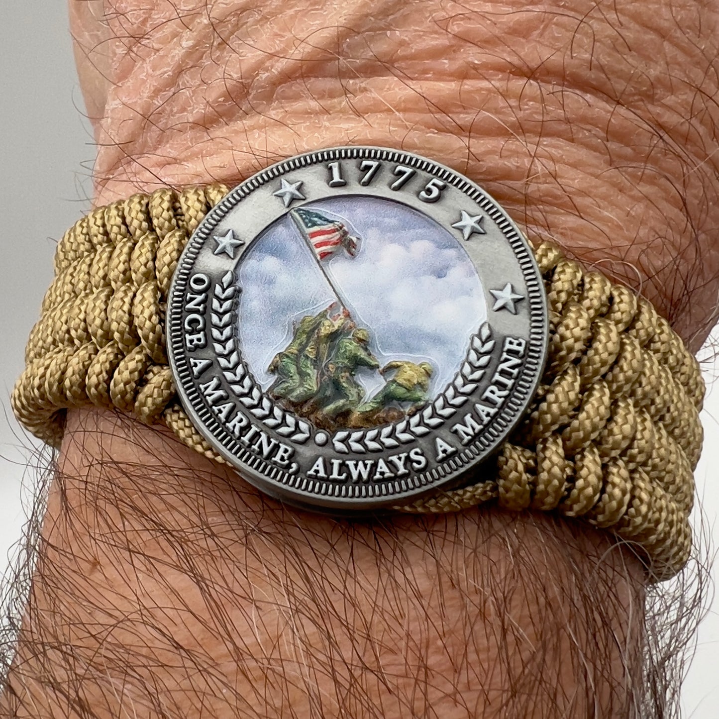 Thin, wide, flexible and comfortable braided United States Marine Corps Iwo Jima bracelet featuring an antique silver plated Iwo Jima flag raising medallion, a gold Cobra style tactical buckle and woven with gold Type-1 paracord.