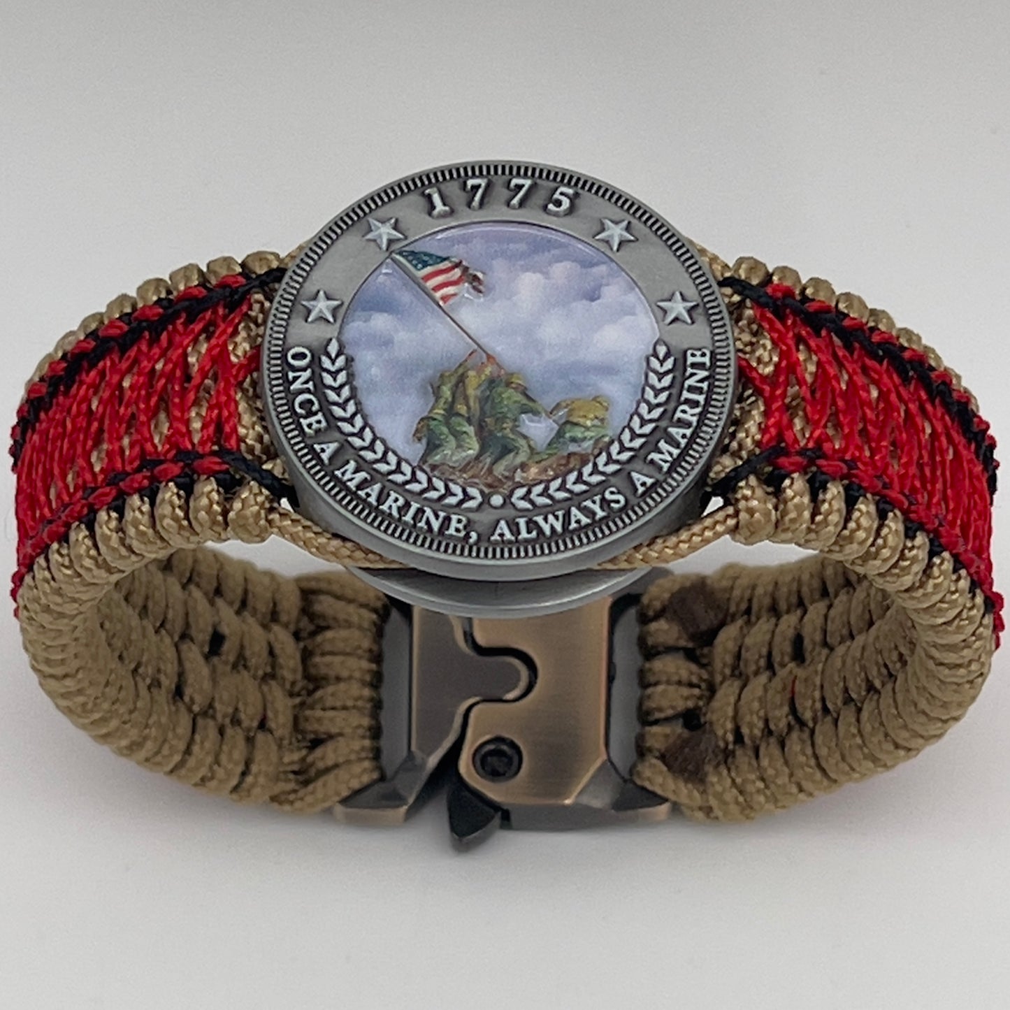Thin, medium width, flexible and comfortable braided United States Marine Corps Iwo Jima bracelet featuring a UV painted antique silver plated Iwo Jima flag raising medallion, a gold Cobra style tactical buckle and woven with gold Type-1 paracord and Imperial Red and black nano cord.