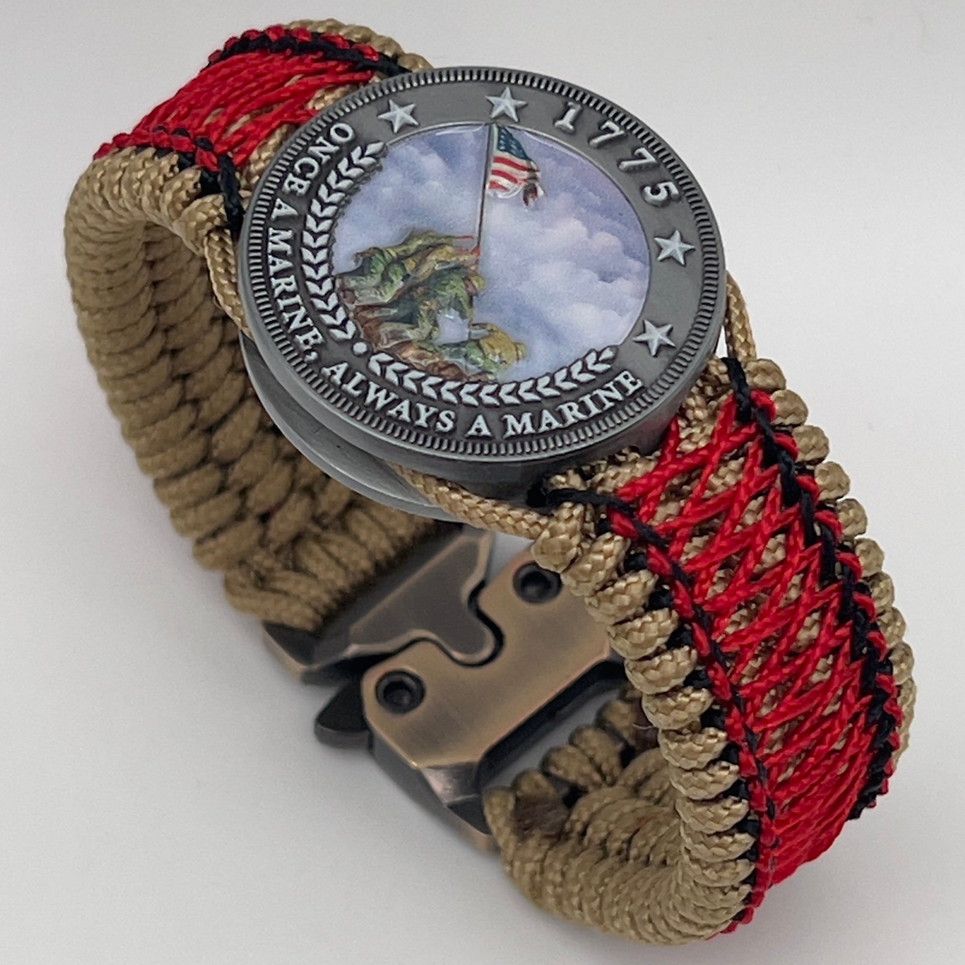 Thin, medium width, flexible and comfortable braided United States Marine Corps Iwo Jima bracelet featuring a UV painted antique silver plated Iwo Jima flag raising medallion, a gold Cobra style tactical buckle and woven with gold Type-1 paracord and Imperial Red and black nano cord.