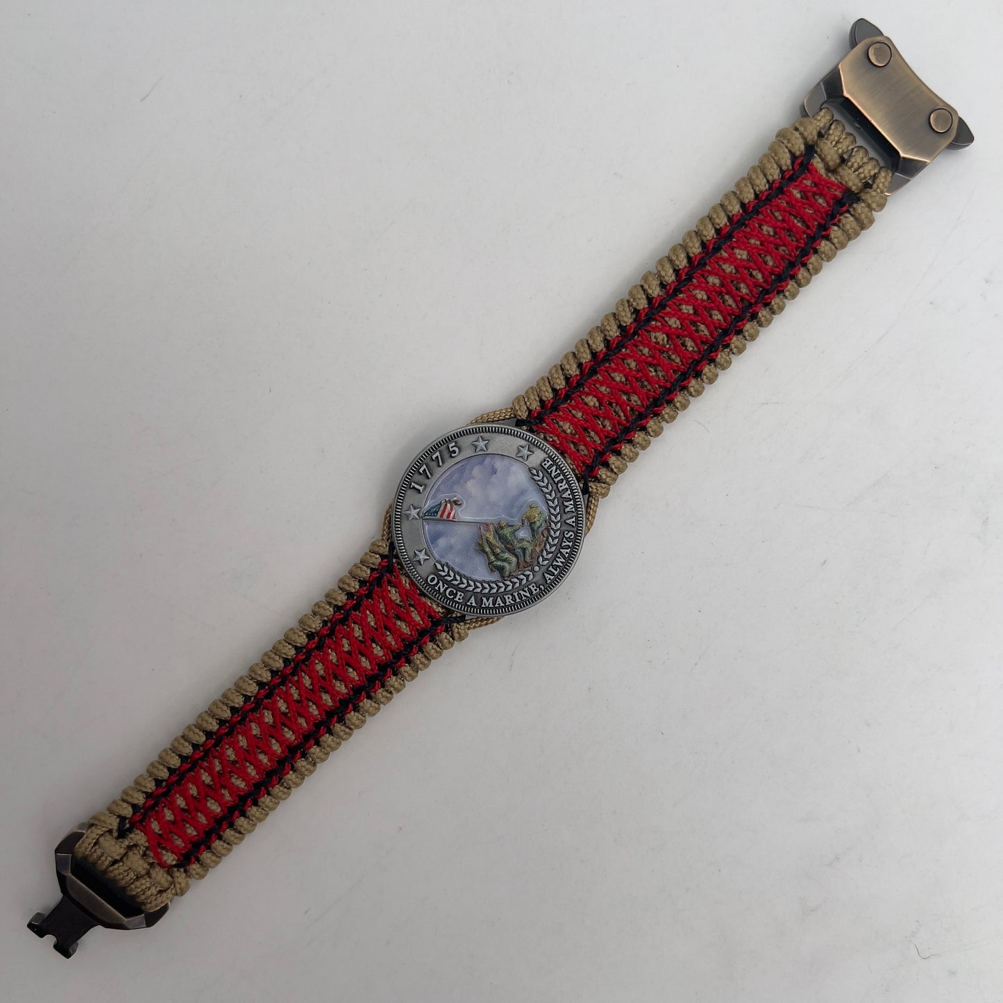 Thin, medium width, flexible and comfortable braided United States Marine Corps Iwo Jima bracelet featuring a UV painted antique silver plated Iwo Jima flag raising medallion, a gold Cobra style tactical buckle and woven with gold Type-1 paracord and Imperial Red and black nano cord.