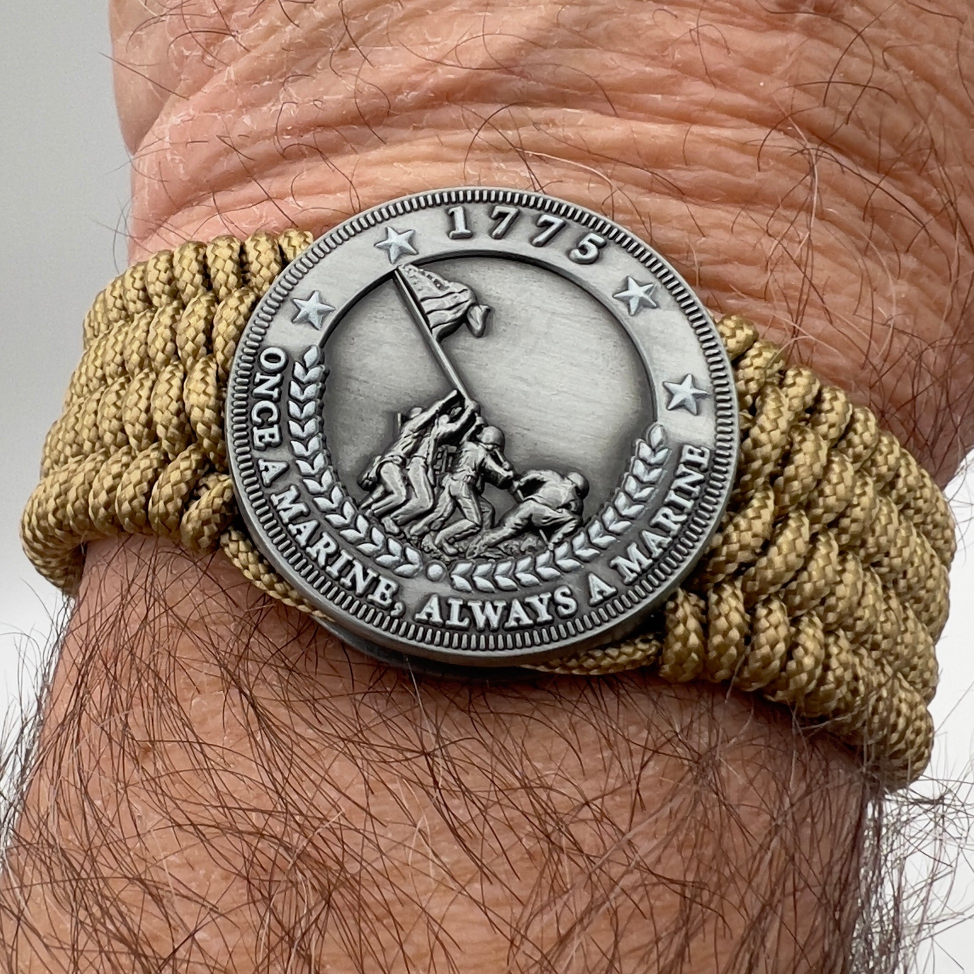 Thin, wide, flexible and comfortable braided United States Marine Corps Iwo Jima bracelet featuring an antique silver plated Iwo Jima flag raising medallion, a gold Cobra style tactical buckle and woven with gold Type-1 paracord.