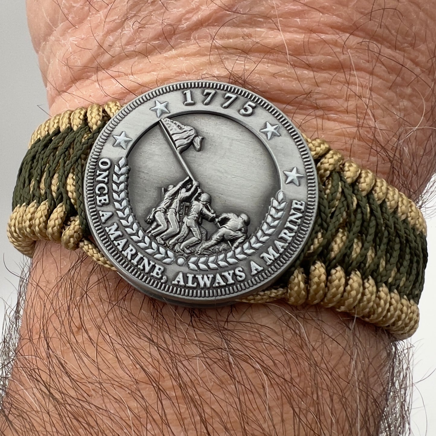 Thin, wide, flexible and comfortable braided United States Marine Corps Iwo Jima bracelet featuring an antique silver plated Iwo Jima flag raising medallion, a gold Cobra style tactical buckle and woven with gold Type-1 paracord and Olive Drab nano cord.