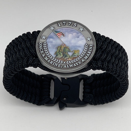 Thin, wide, flexible and comfortable braided United States Marine Corps Iwo Jima bracelet featuring an antique silver plated UV painted Iwo Jima flag raising medallion, a black Cobra style tactical buckle and woven with black Type-1 paracord.