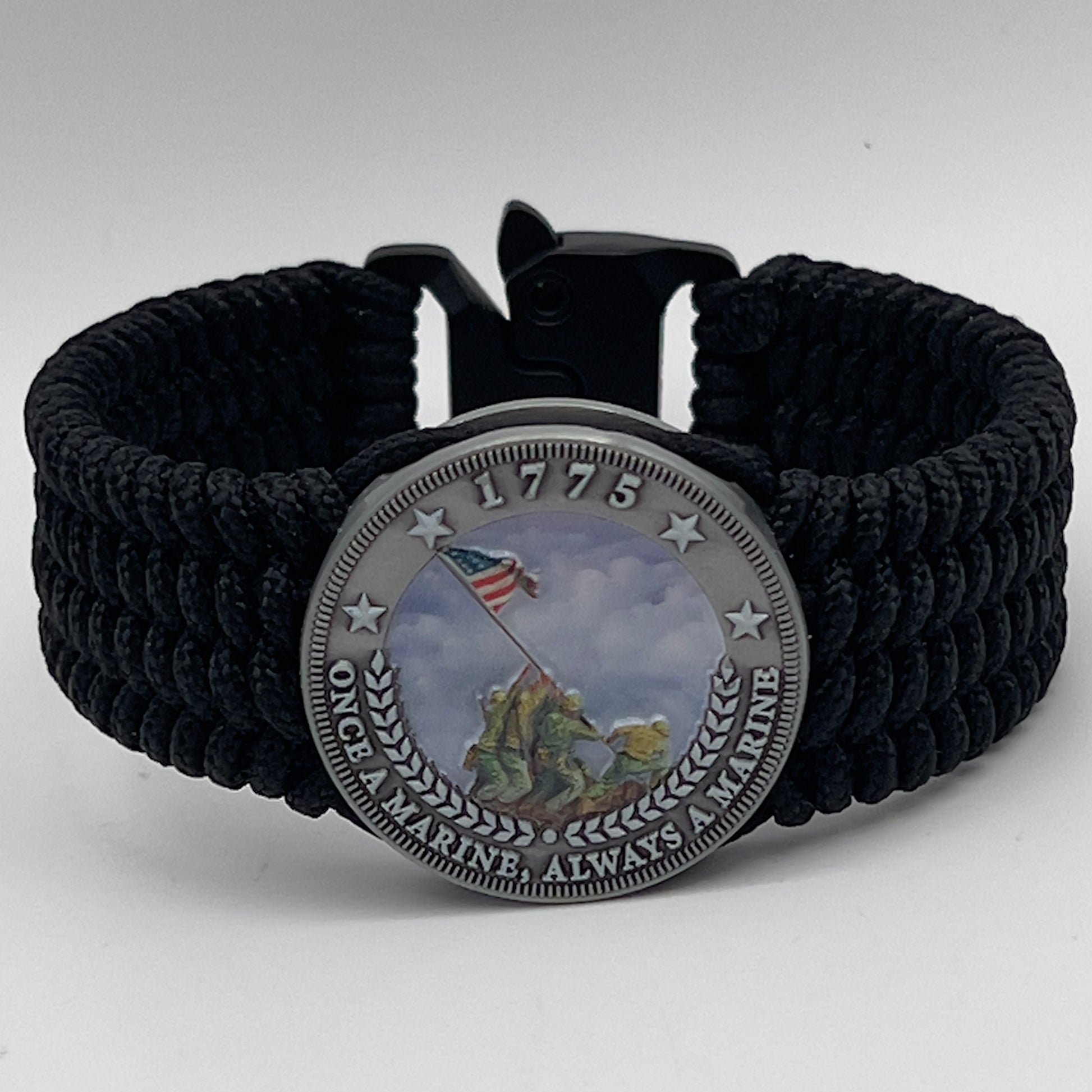 Thin, wide, flexible and comfortable braided United States Marine Corps Iwo Jima bracelet featuring an antique silver plated UV painted Iwo Jima flag raising medallion, a black Cobra style tactical buckle and woven with black Type-1 paracord.