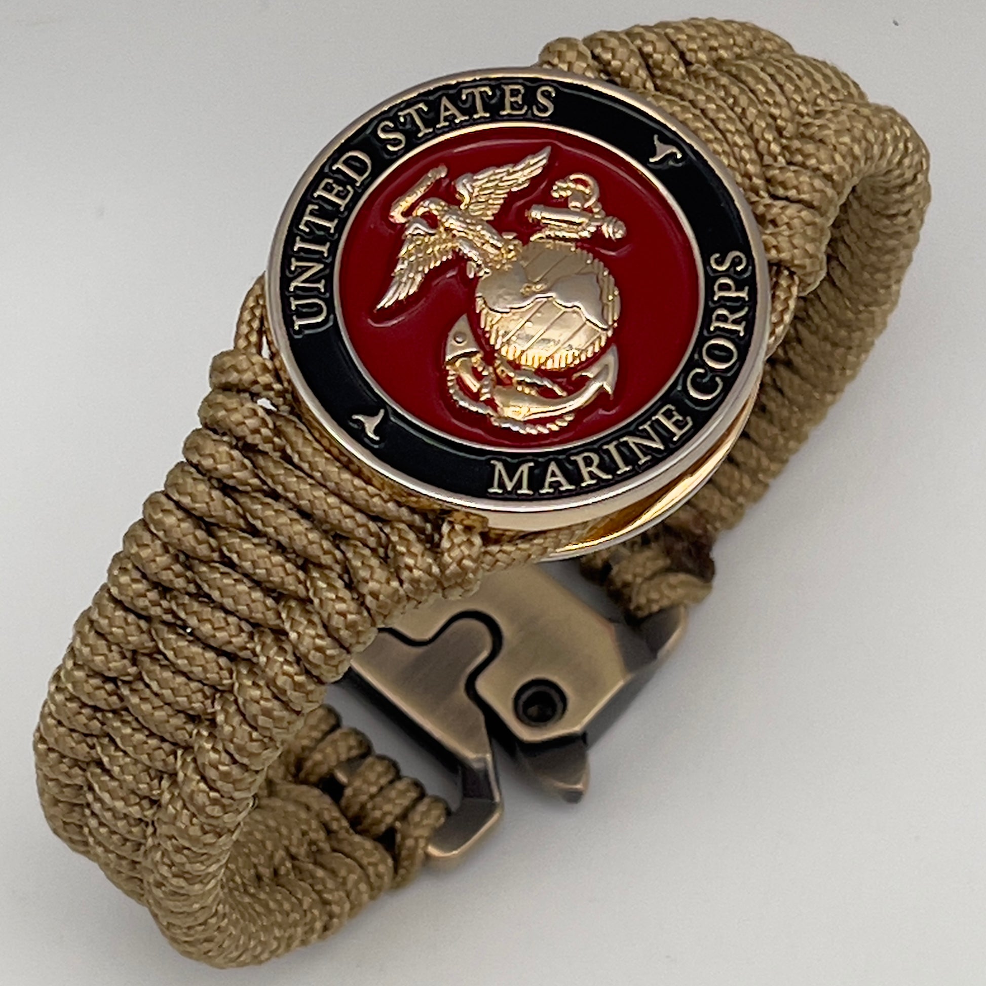 Thick, narrow, flexible and comfortable braided United States Marine Corps bracelet featuring a 24K gold plated USMC officer Eagle Globe and Anchor medallion, a gold Cobra style tactical buckle and woven with gold Type-1 paracord.