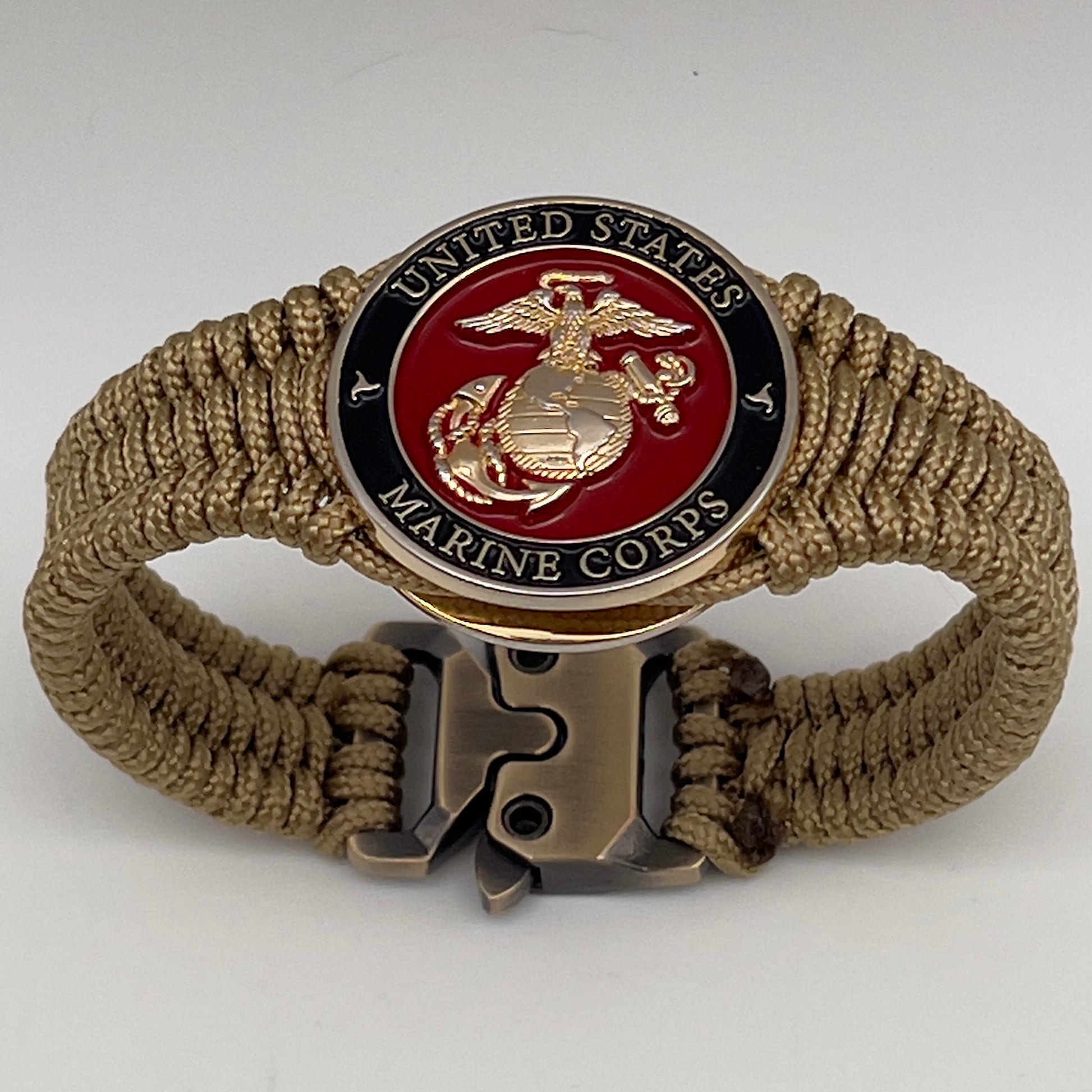 Thick, narrow, flexible and comfortable braided United States Marine Corps bracelet featuring a 24K gold plated USMC officer Eagle Globe and Anchor medallion, a gold Cobra style tactical buckle and woven with gold Type-1 paracord.