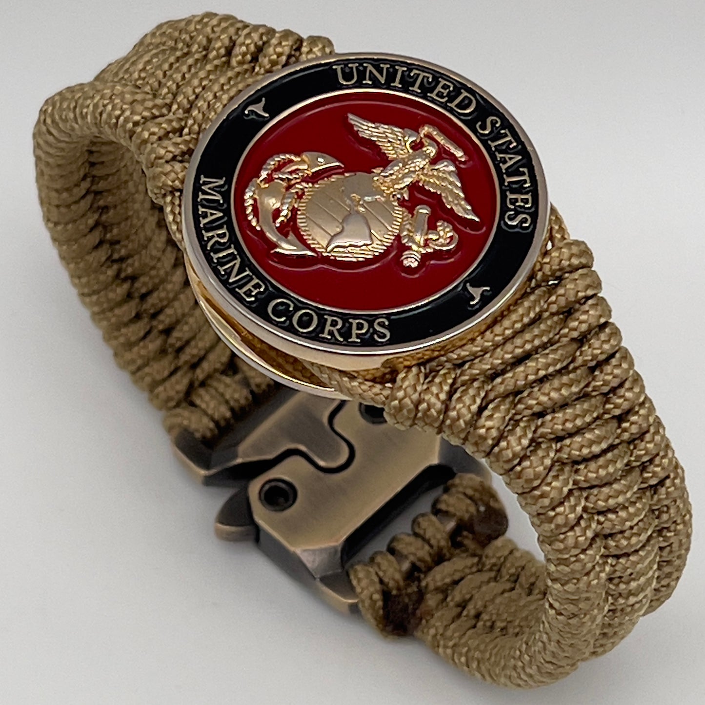 Thick, narrow, flexible and comfortable braided United States Marine Corps bracelet featuring a 24K gold plated USMC officer Eagle Globe and Anchor medallion, a gold Cobra style tactical buckle and woven with gold Type-1 paracord.