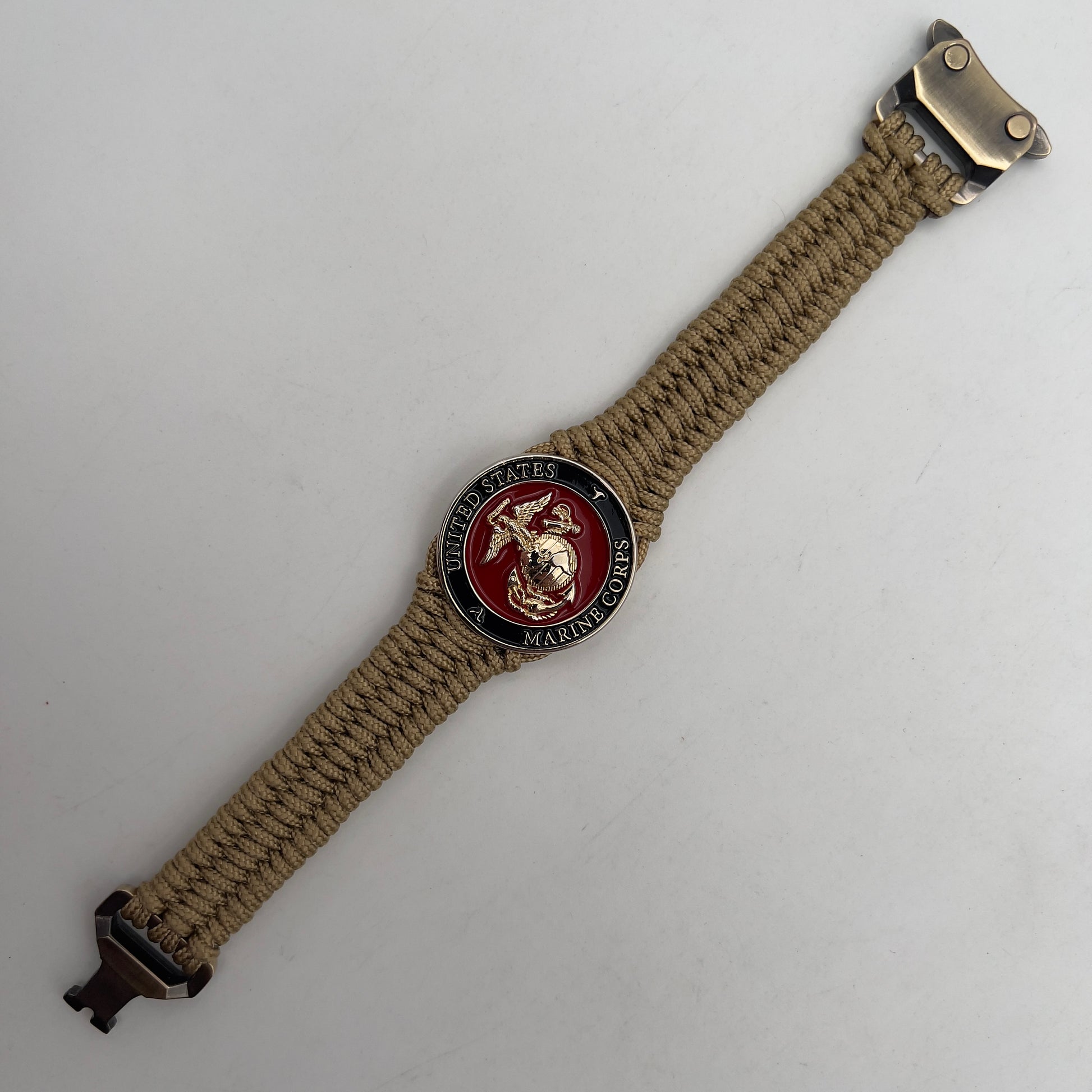 Thick, narrow, flexible and comfortable braided United States Marine Corps bracelet featuring a 24K gold plated USMC officer Eagle Globe and Anchor medallion, a gold Cobra style tactical buckle and woven with gold Type-1 paracord.