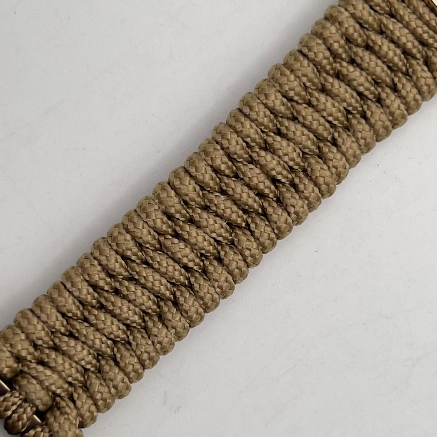 Thick, narrow, flexible and comfortable braided United States Marine Corps bracelet featuring a 24K gold plated USMC officer Eagle Globe and Anchor medallion, a gold Cobra style tactical buckle and woven with gold Type-1 paracord.