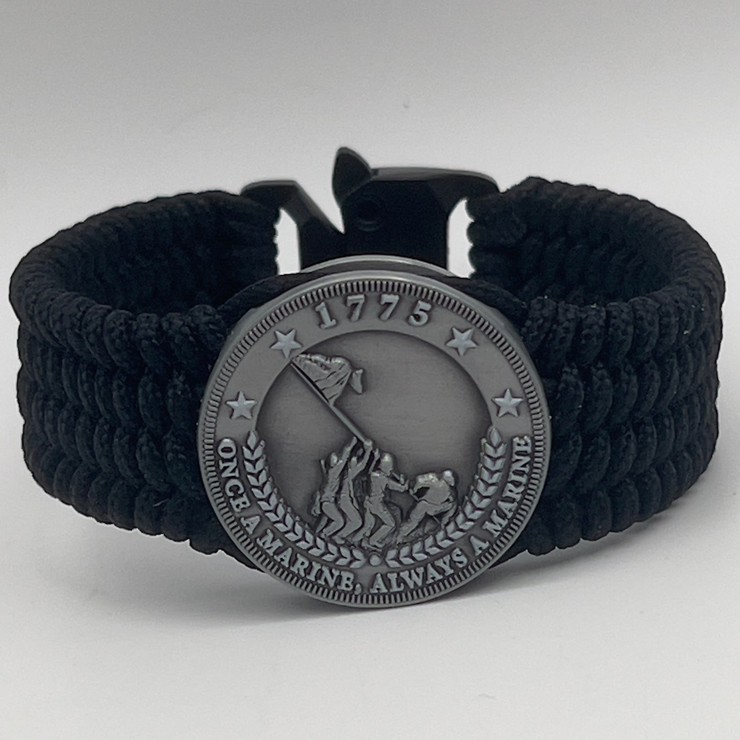 Thin, wide, flexible and comfortable braided United States Marine Corps Iwo Jima bracelet featuring an antique silver plated Iwo Jima flag raising medallion, a black Cobra style tactical buckle and woven with black Type-1 paracord.