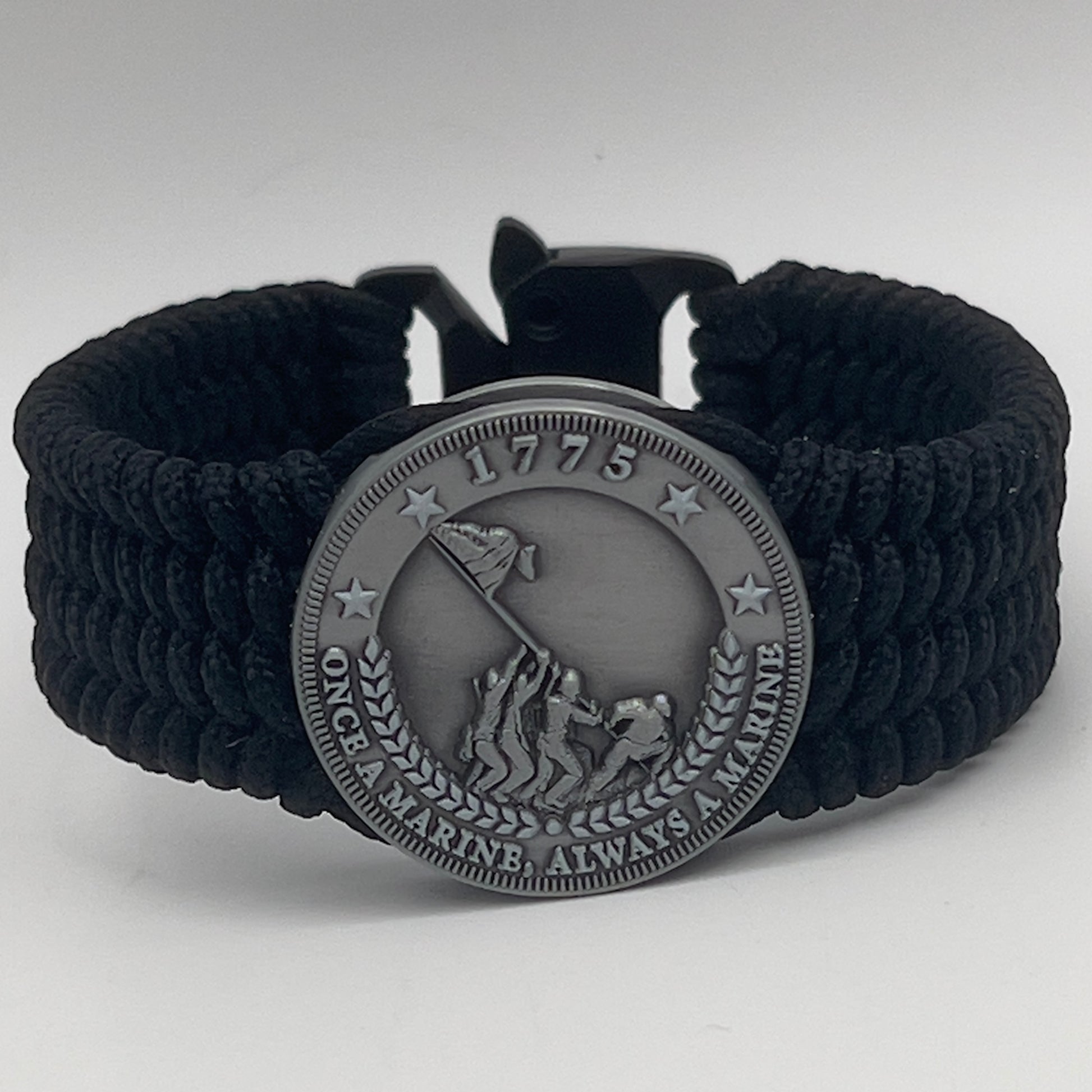 Thin, wide, flexible and comfortable braided United States Marine Corps Iwo Jima bracelet featuring an antique silver plated Iwo Jima flag raising medallion, a black Cobra style tactical buckle and woven with black Type-1 paracord.