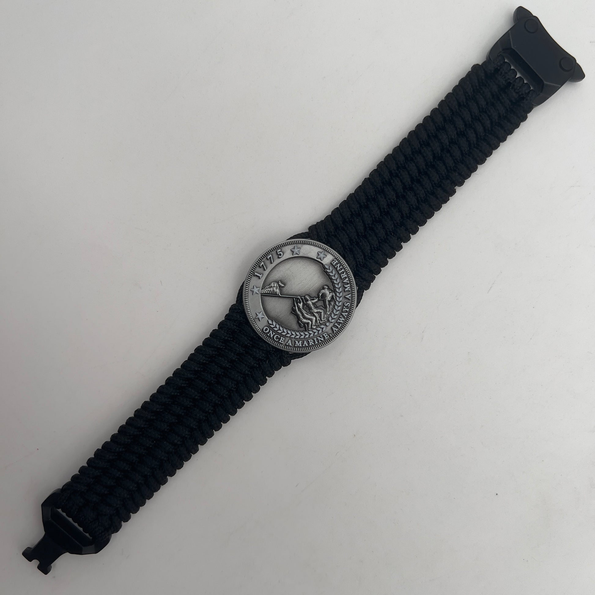 Thin, wide, flexible and comfortable braided United States Marine Corps Iwo Jima bracelet featuring an antique silver plated Iwo Jima flag raising medallion, a black Cobra style tactical buckle and woven with black Type-1 paracord.