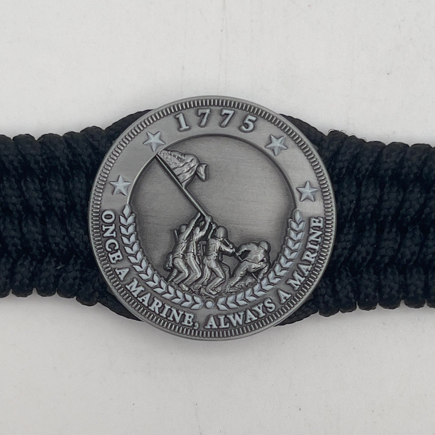 Thin, wide, flexible and comfortable braided United States Marine Corps Iwo Jima bracelet featuring an antique silver plated Iwo Jima flag raising medallion, a black Cobra style tactical buckle and woven with black Type-1 paracord.