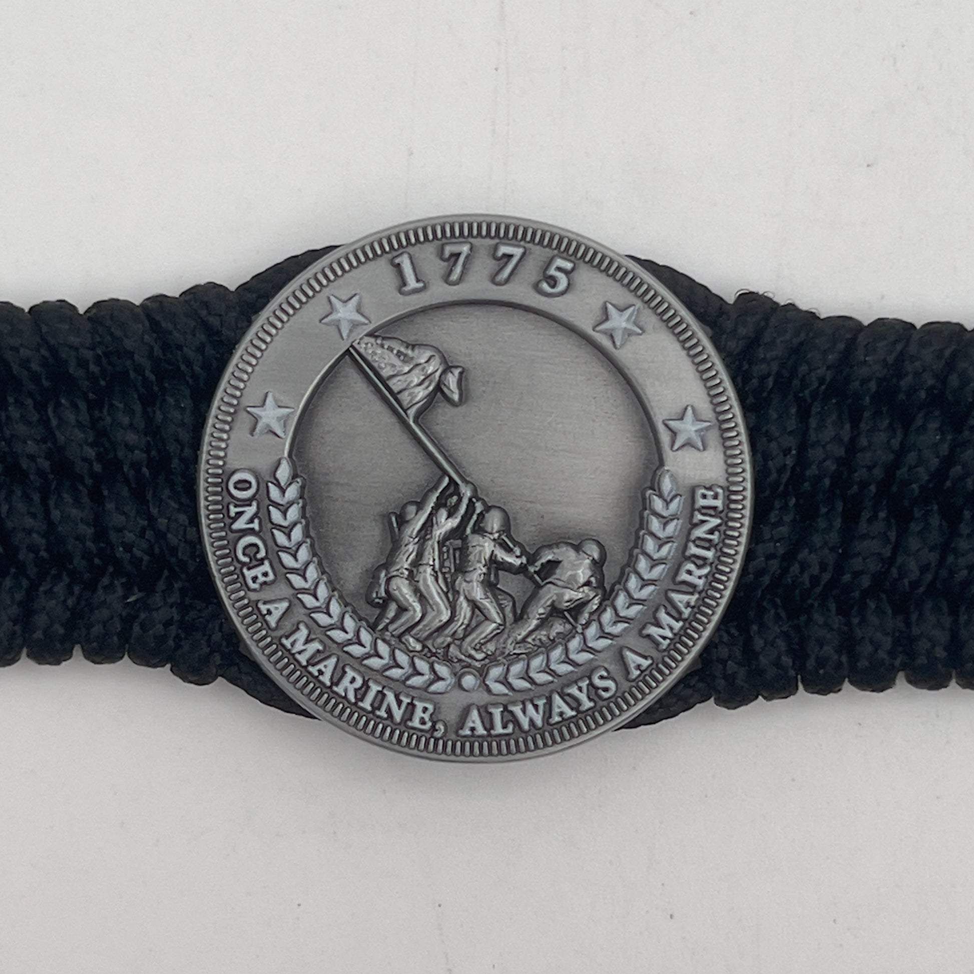 Thin, wide, flexible and comfortable braided United States Marine Corps Iwo Jima bracelet featuring an antique silver plated Iwo Jima flag raising medallion, a black Cobra style tactical buckle and woven with black Type-1 paracord.