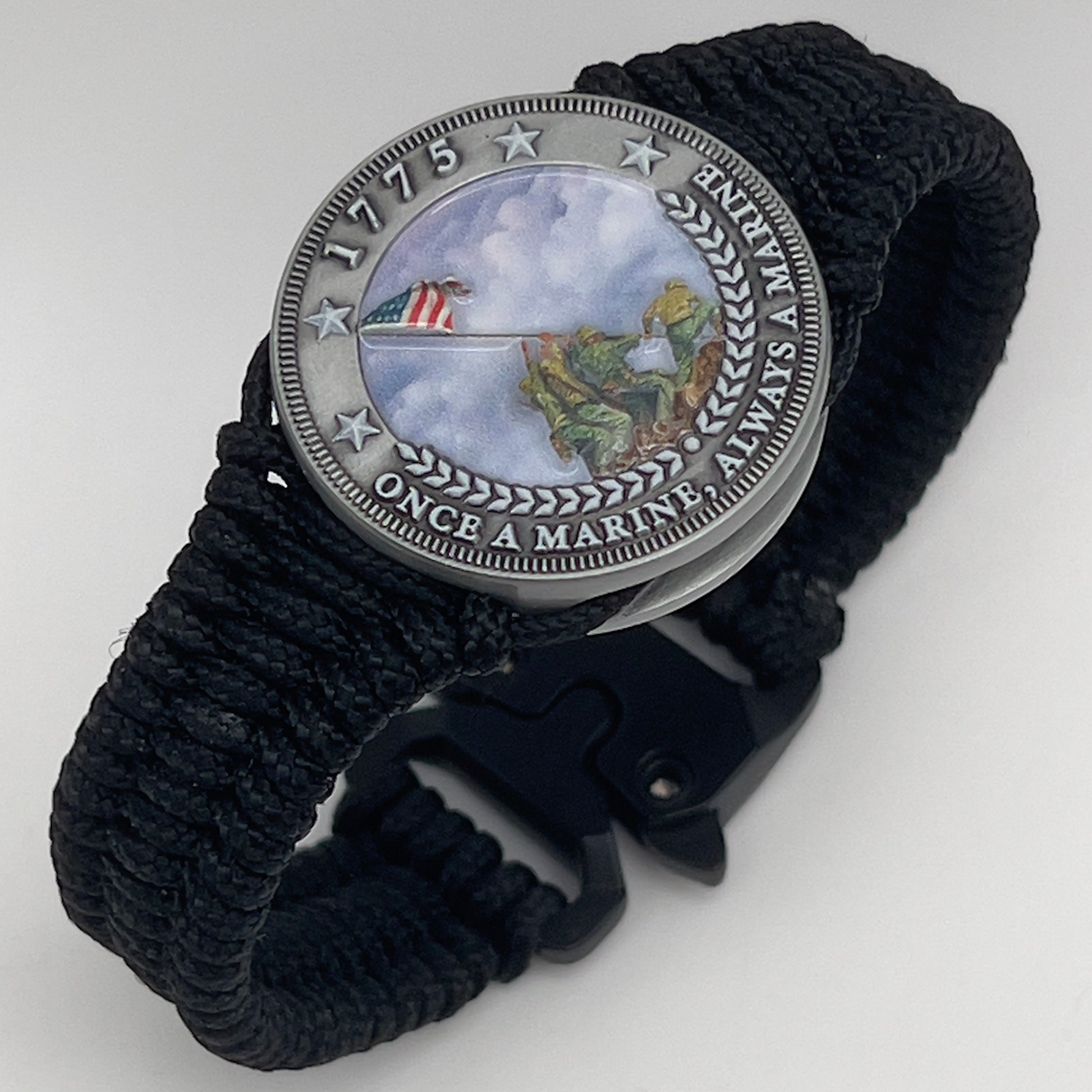 Thin, narrow and comfortable braided United States Marine Corps Iwo Jima bracelet featuring an antique silver plated UV painted Iwo Jima flag raising medallion, a black Cobra style tactical buckle and woven with black type-1 paracord.
