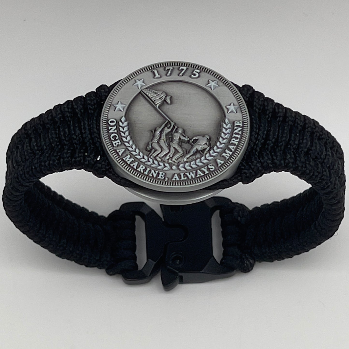 Thin, narrow and comfortable braided United States Marine Corps Iwo Jima bracelet featuring an antique silver plated Iwo Jima flag raising medallion, a black Cobra style tactical buckle and woven with black type-1 paracord.