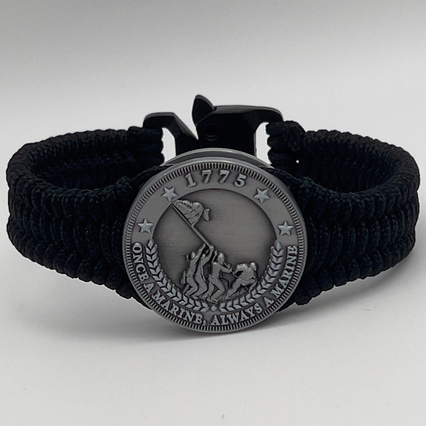 Thin, narrow and comfortable braided United States Marine Corps Iwo Jima bracelet featuring an antique silver plated Iwo Jima flag raising medallion, a black Cobra style tactical buckle and woven with black type-1 paracord.