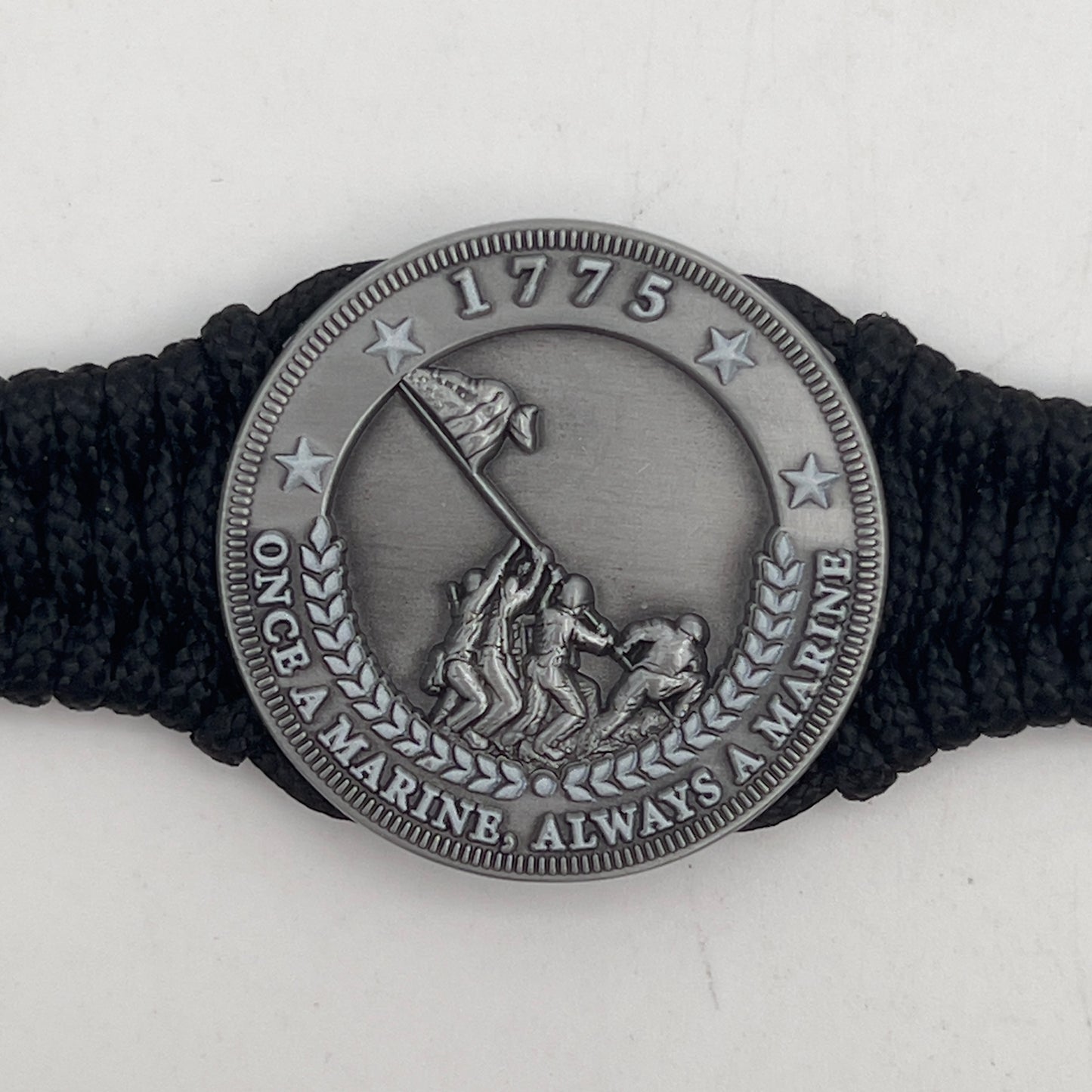 Thin, narrow and comfortable braided United States Marine Corps Iwo Jima bracelet featuring an antique silver plated Iwo Jima flag raising medallion, a black Cobra style tactical buckle and woven with black type-1 paracord.