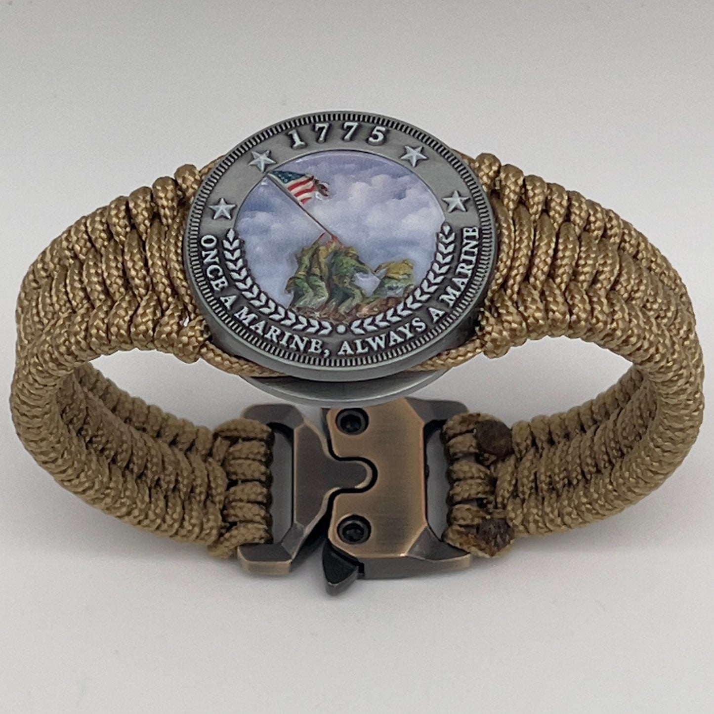 Thin, narrow, flexible and comfortable braided United States Marine Corps Iwo Jima bracelet featuring an antique silver plated UV painted Iwo Jima flag raising medallion, a gold Cobra style tactical buckle and woven with gold type-1 paracord.