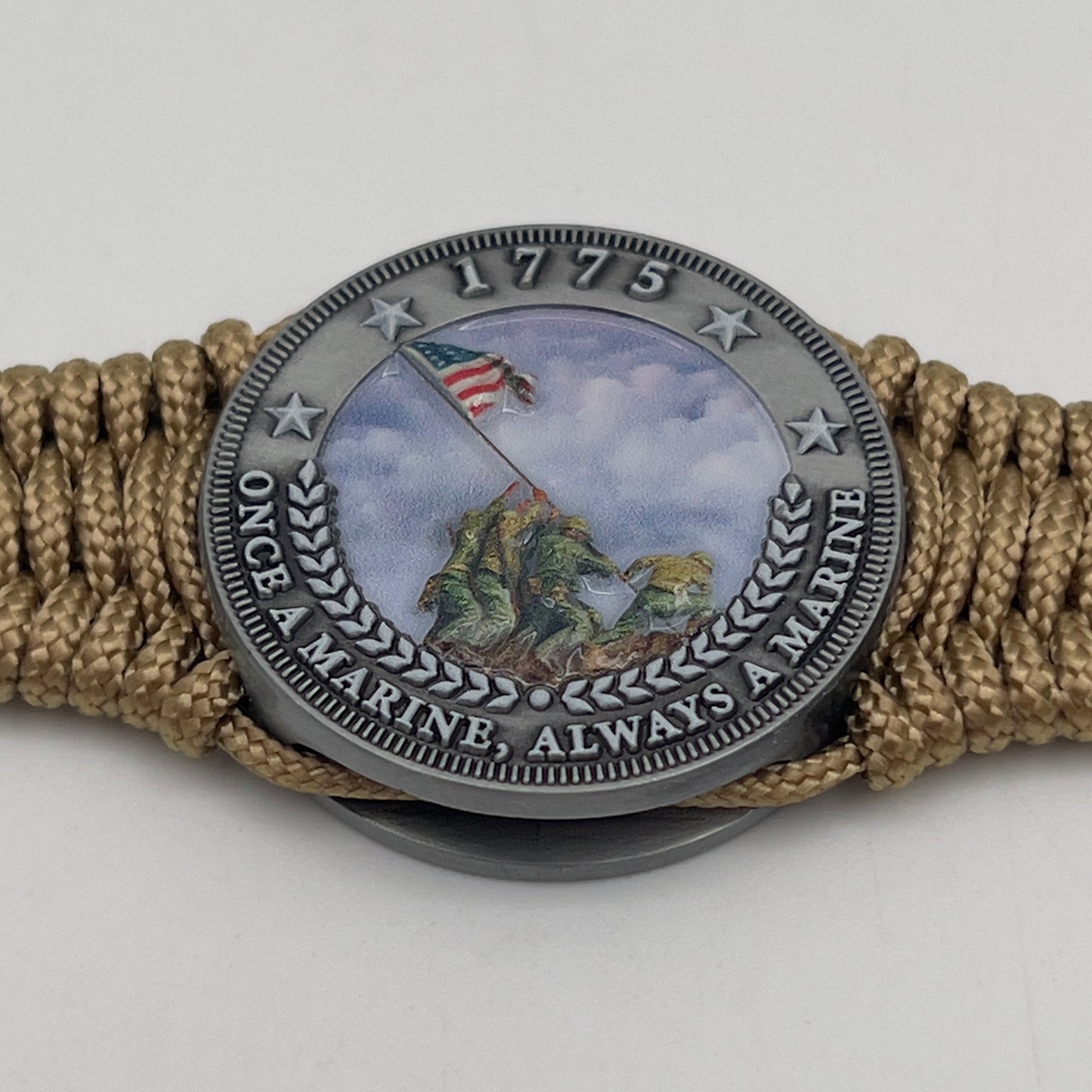 Thin, narrow, flexible and comfortable braided United States Marine Corps Iwo Jima bracelet featuring an antique silver plated UV painted Iwo Jima flag raising medallion, a gold Cobra style tactical buckle and woven with gold type-1 paracord.