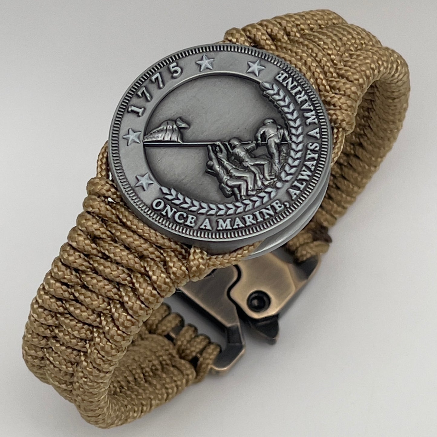 Thin, narrow, flexible and comfortable braided United States Marine Corps Iwo Jima bracelet featuring an antique silver plated Iwo Jima flag raising medallion, a gold Cobra style tactical buckle and woven with gold type-1 paracord.