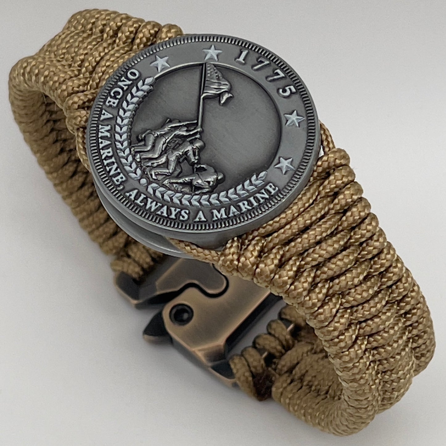 Thin, narrow, flexible and comfortable braided United States Marine Corps Iwo Jima bracelet featuring an antique silver plated Iwo Jima flag raising medallion, a gold Cobra style tactical buckle and woven with gold type-1 paracord.