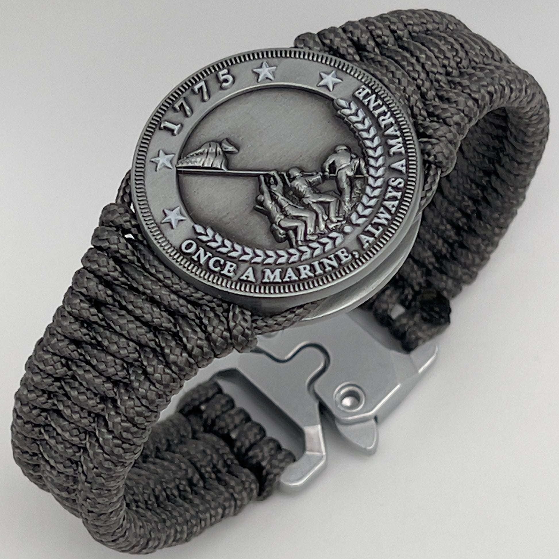 Thin, narrow, flexible and comfortable braided United States Marine Corps Iwo Jima bracelet featuring an antique silver plated Iwo Jima flag raising medallion, a silver Cobra style tactical buckle and woven with Charcoal Gray type-1 paracord.
