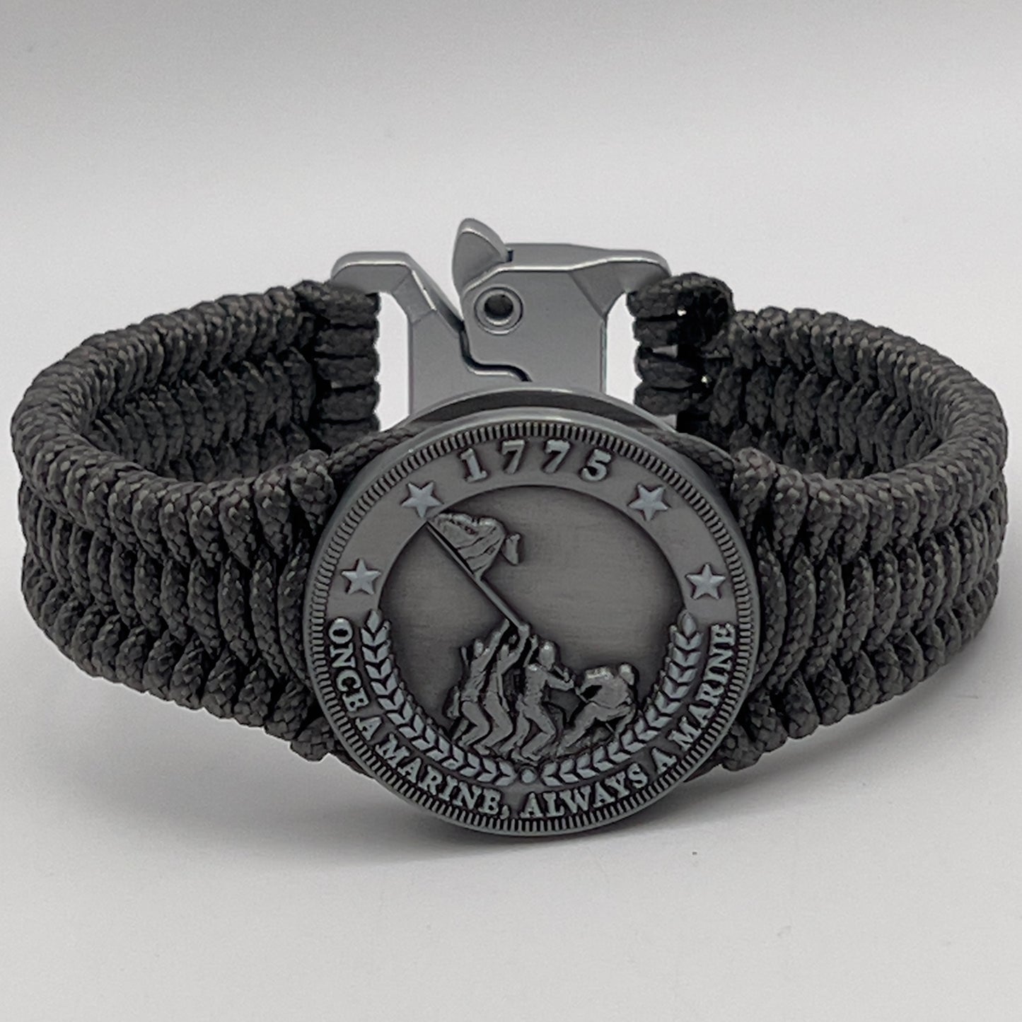 Thin, narrow, flexible and comfortable braided United States Marine Corps Iwo Jima bracelet featuring an antique silver plated Iwo Jima flag raising medallion, a silver Cobra style tactical buckle and woven with Charcoal Gray type-1 paracord.