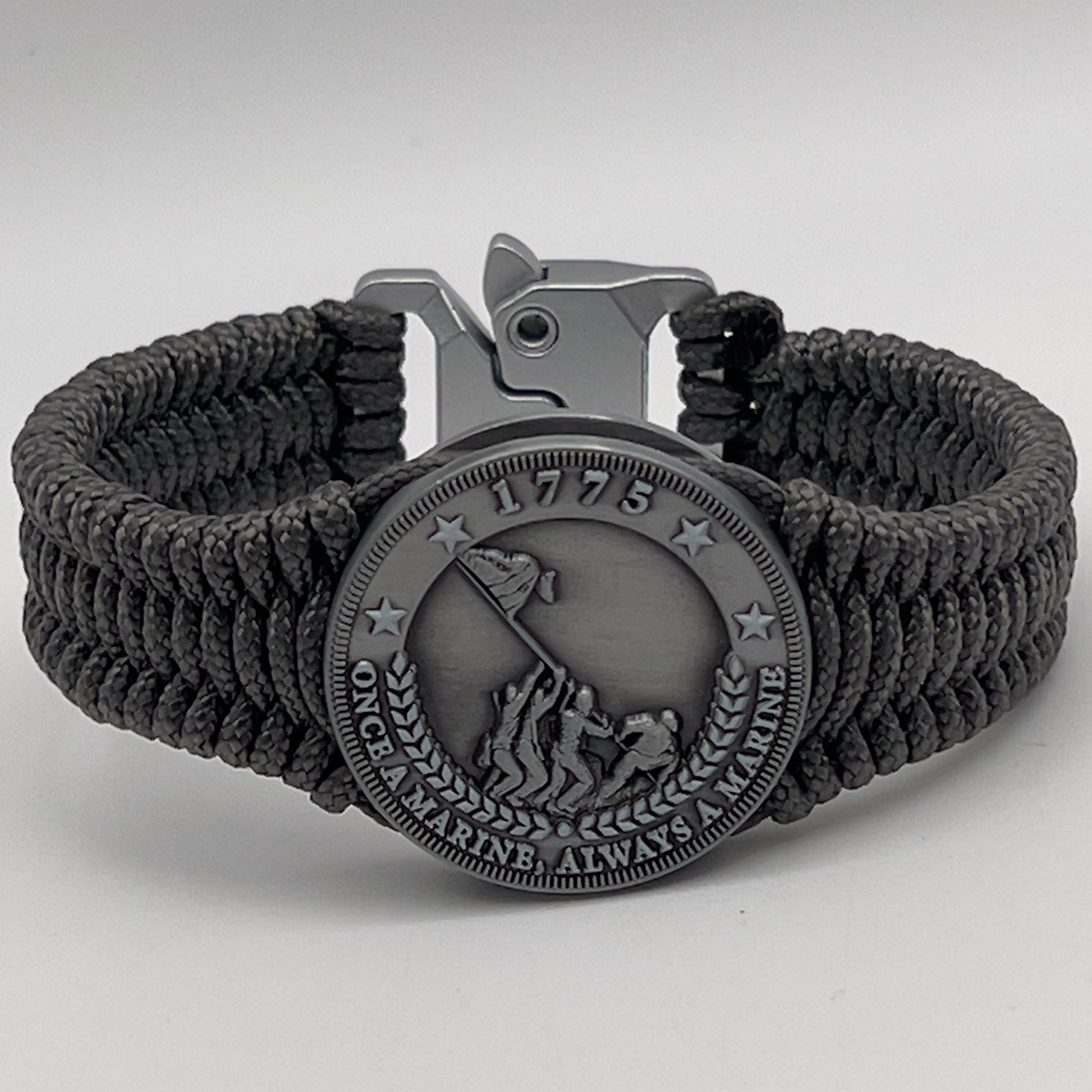 Thin, narrow, flexible and comfortable braided United States Marine Corps Iwo Jima bracelet featuring an antique silver plated Iwo Jima flag raising medallion, a silver Cobra style tactical buckle and woven with Charcoal Gray type-1 paracord.