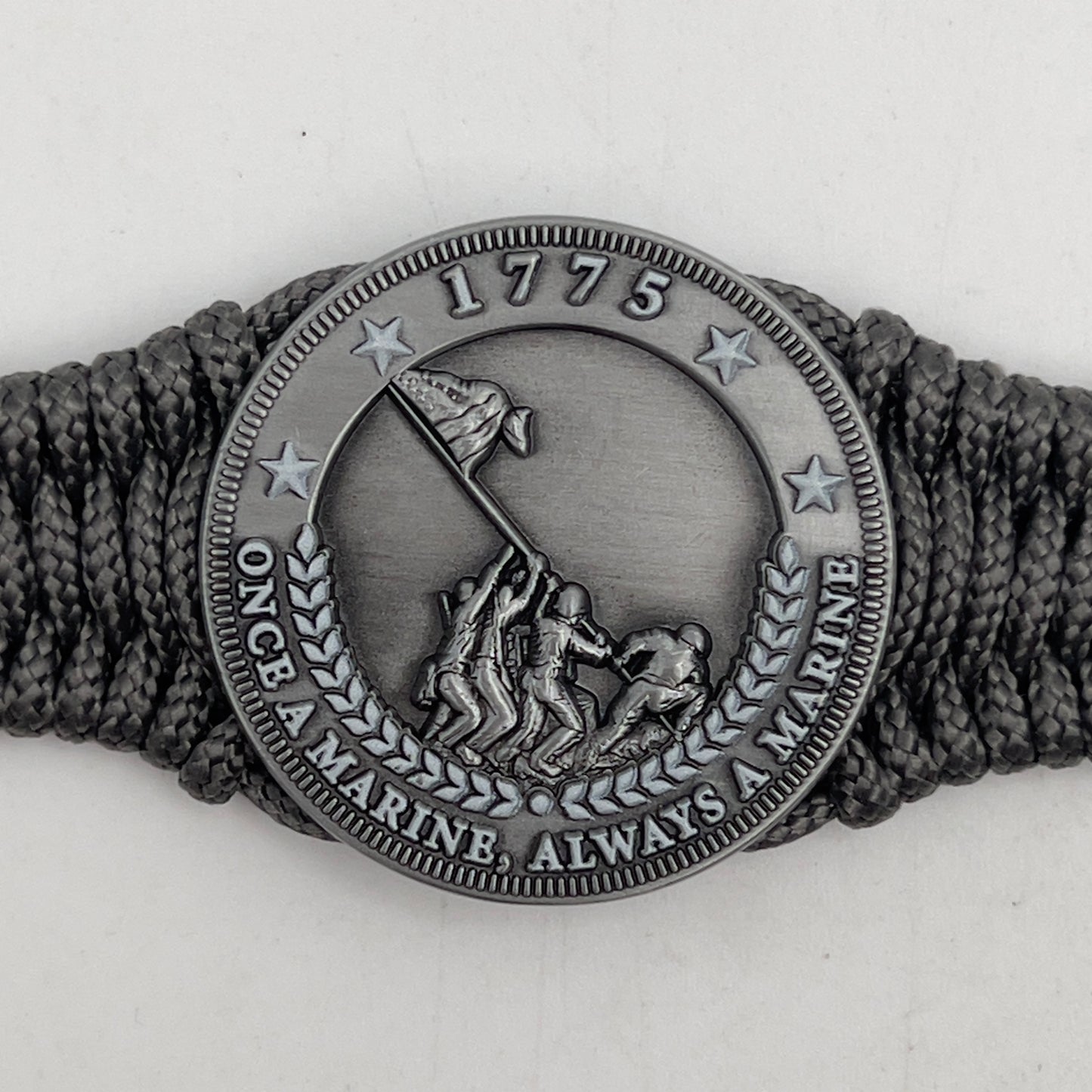 Thin, narrow, flexible and comfortable braided United States Marine Corps Iwo Jima bracelet featuring an antique silver plated Iwo Jima flag raising medallion, a silver Cobra style tactical buckle and woven with Charcoal Gray type-1 paracord.