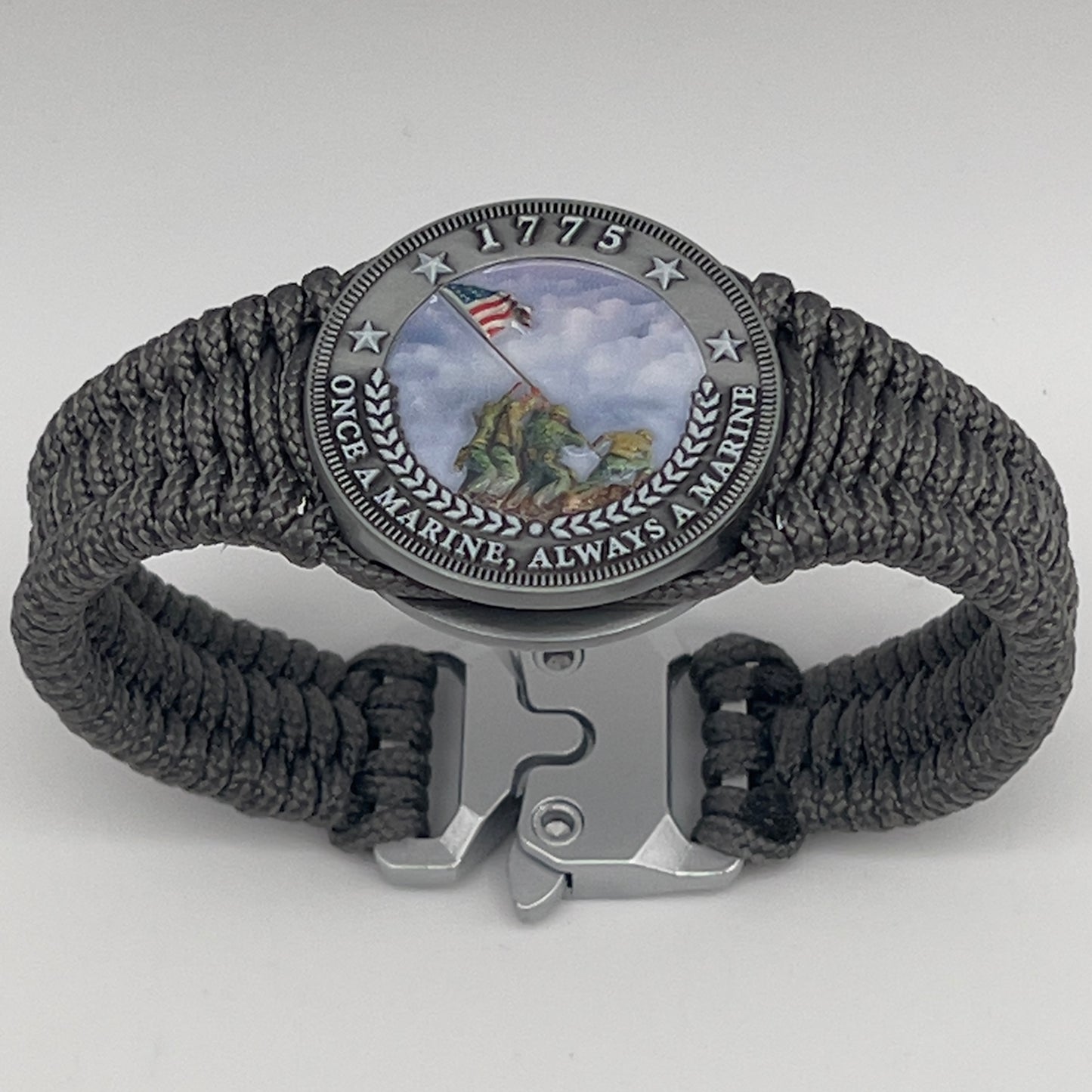 Thin, narrow, flexible and comfortable braided United States Marine Corps Iwo Jima bracelet featuring an antique silver plated UV painted Iwo Jima flag raising medallion, a silver Cobra style tactical buckle and woven with Charcoal Gray type-1 paracord.
