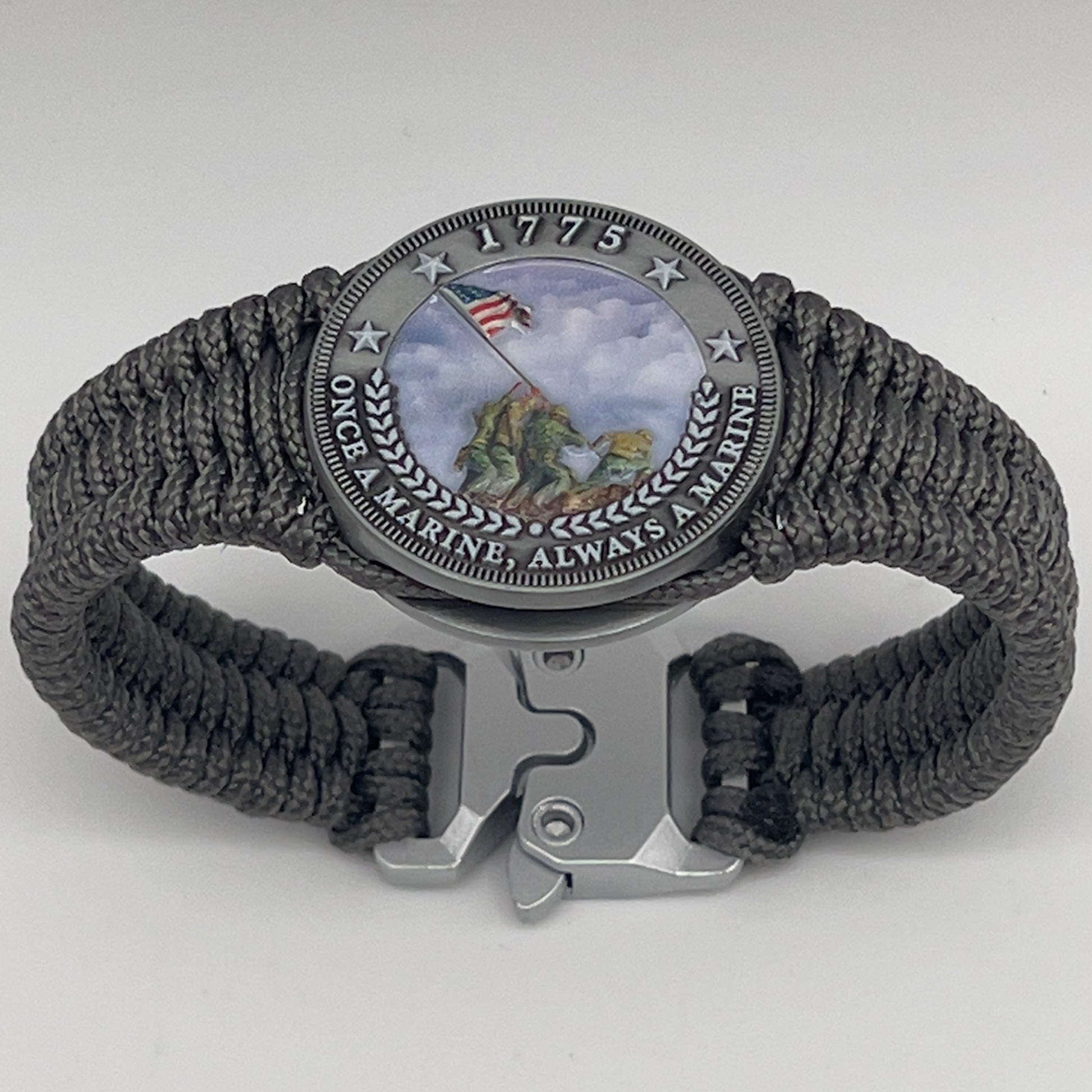Thin, narrow, flexible and comfortable braided United States Marine Corps Iwo Jima bracelet featuring an antique silver plated UV painted Iwo Jima flag raising medallion, a silver Cobra style tactical buckle and woven with Charcoal Gray type-1 paracord.