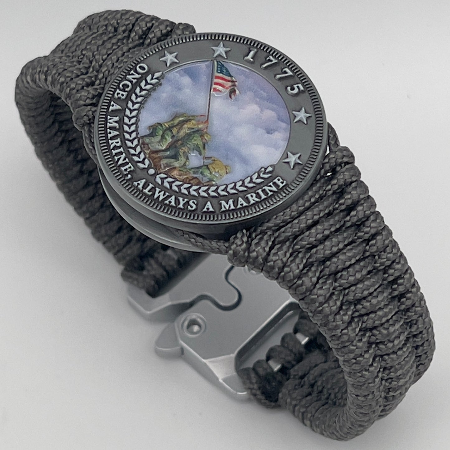Thin, narrow, flexible and comfortable braided United States Marine Corps Iwo Jima bracelet featuring an antique silver plated UV painted Iwo Jima flag raising medallion, a silver Cobra style tactical buckle and woven with Charcoal Gray type-1 paracord.