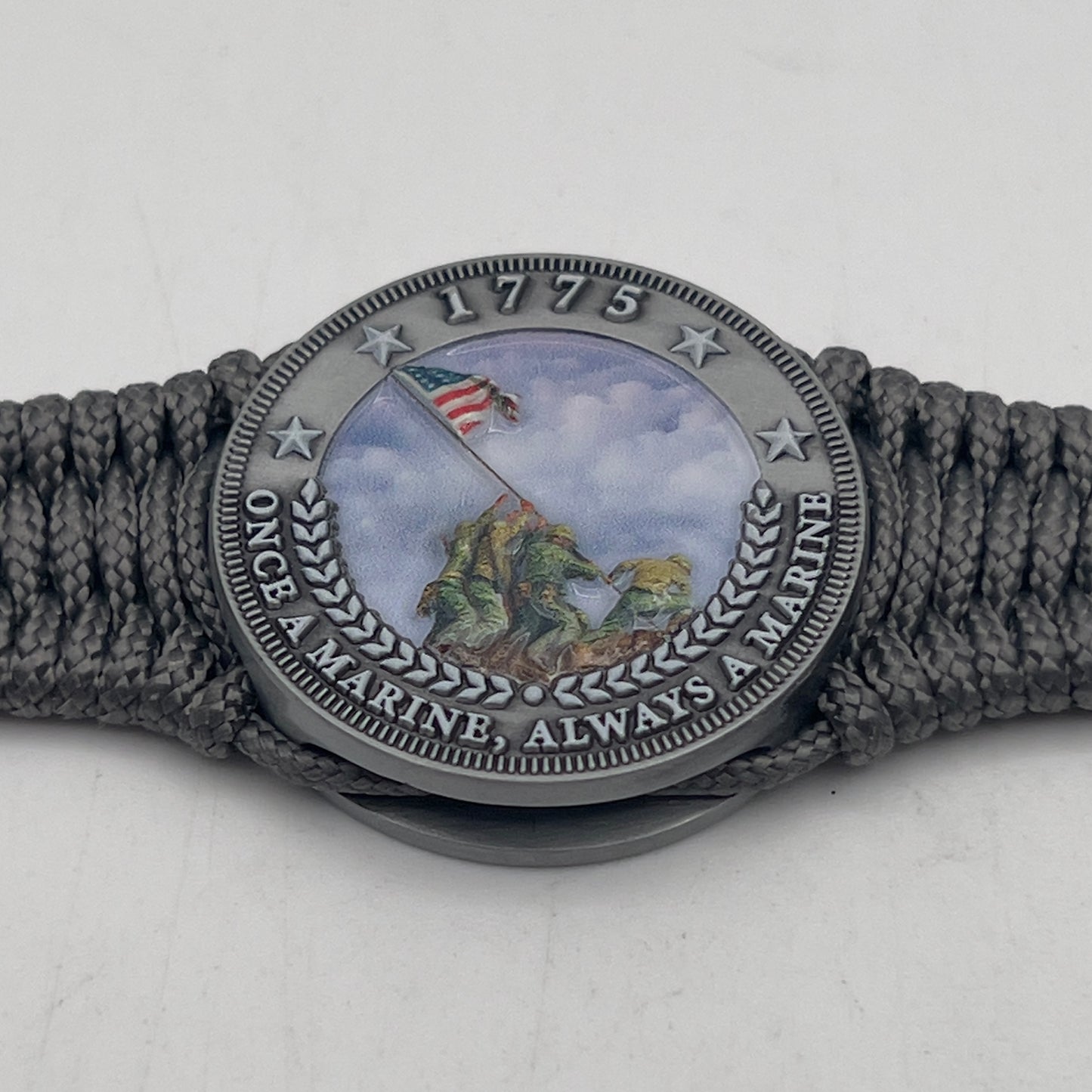 Thin, narrow, flexible and comfortable braided United States Marine Corps Iwo Jima bracelet featuring an antique silver plated UV painted Iwo Jima flag raising medallion, a silver Cobra style tactical buckle and woven with Charcoal Gray type-1 paracord.
