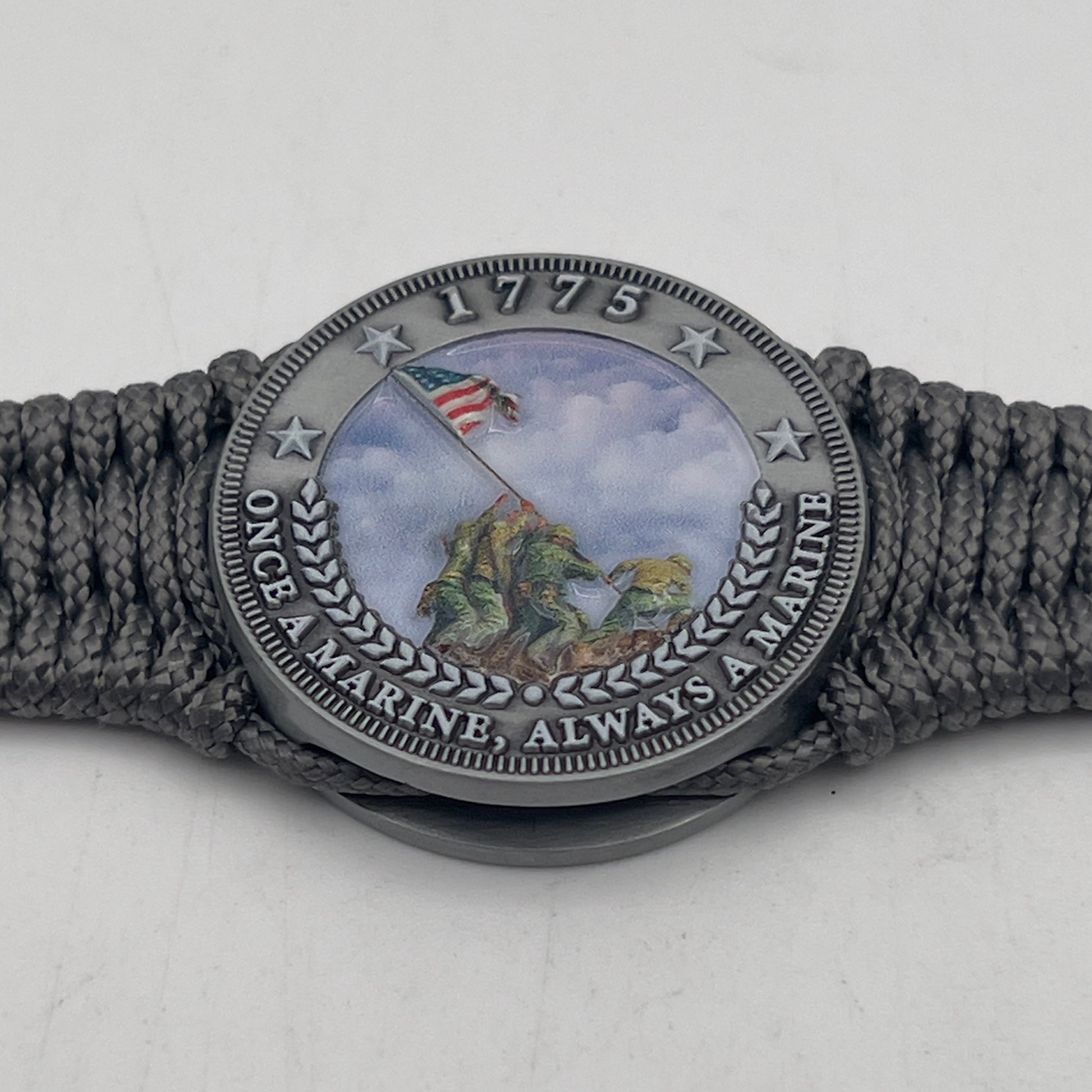 Thin, narrow, flexible and comfortable braided United States Marine Corps Iwo Jima bracelet featuring an antique silver plated UV painted Iwo Jima flag raising medallion, a silver Cobra style tactical buckle and woven with Charcoal Gray type-1 paracord.