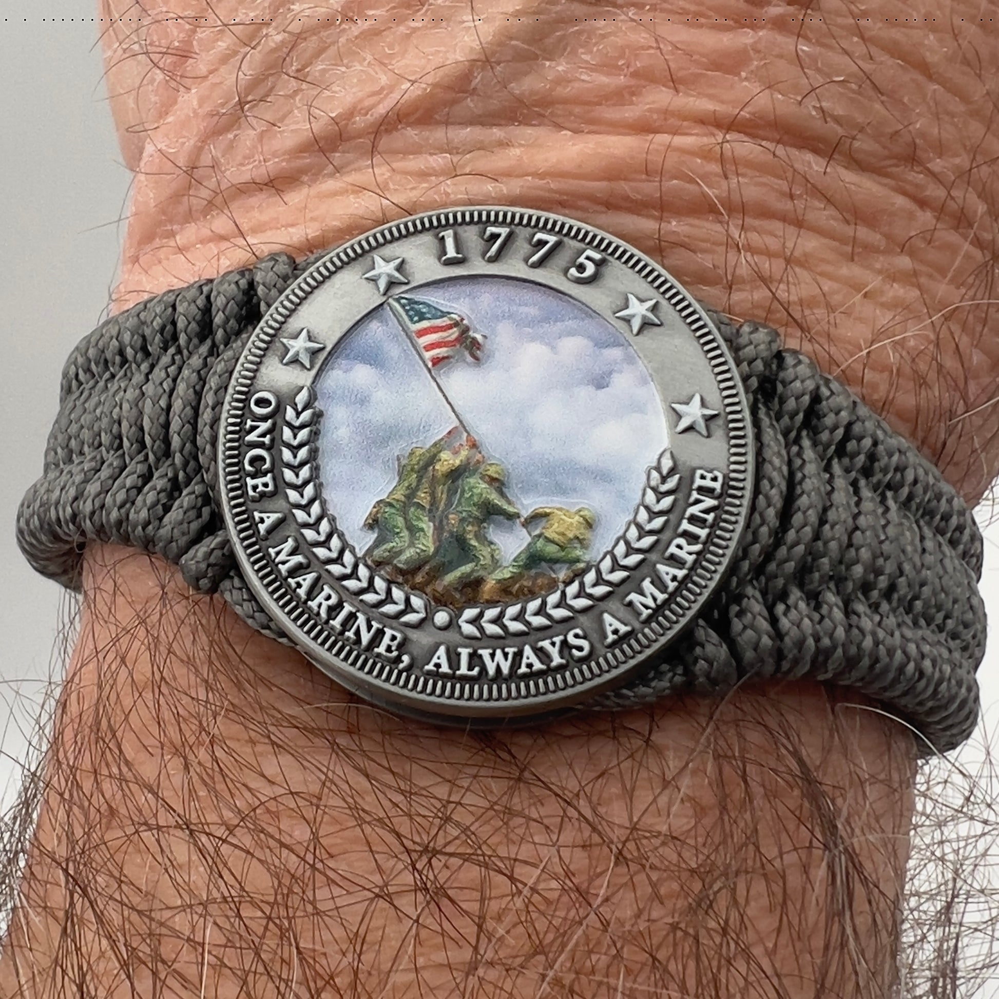 Thin, narrow, flexible and comfortable braided United States Marine Corps Iwo Jima bracelet featuring an antique silver plated UV painted Iwo Jima flag raising medallion, a silver Cobra style tactical buckle and woven with Charcoal Gray type-1 paracord.