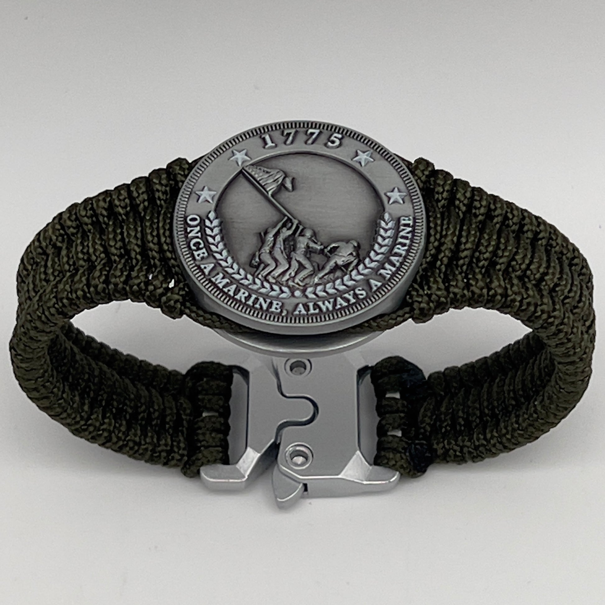 Thin, narrow, flexible and comfortable braided United States Marine Corps Iwo Jima bracelet featuring an antique silver plated UV painted Iwo Jima flag raising medallion, a silver Cobra style tactical buckle and woven with Olive Drab type-1 paracord.