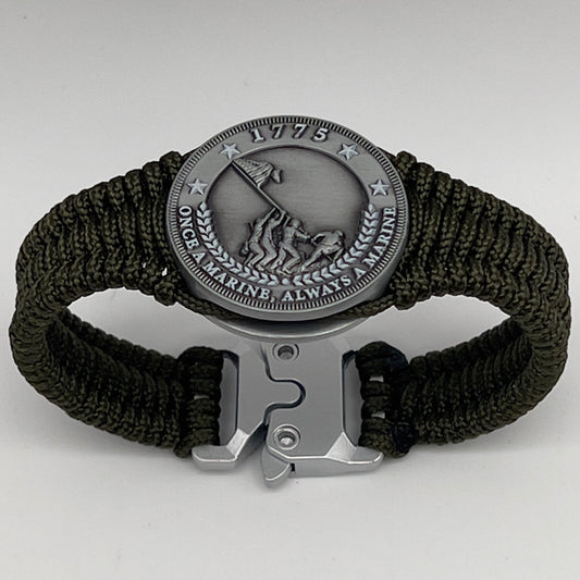 Thin, narrow, flexible and comfortable braided United States Marine Corps Iwo Jima bracelet featuring an antique silver plated UV painted Iwo Jima flag raising medallion, a silver Cobra style tactical buckle and woven with Olive Drab type-1 paracord.