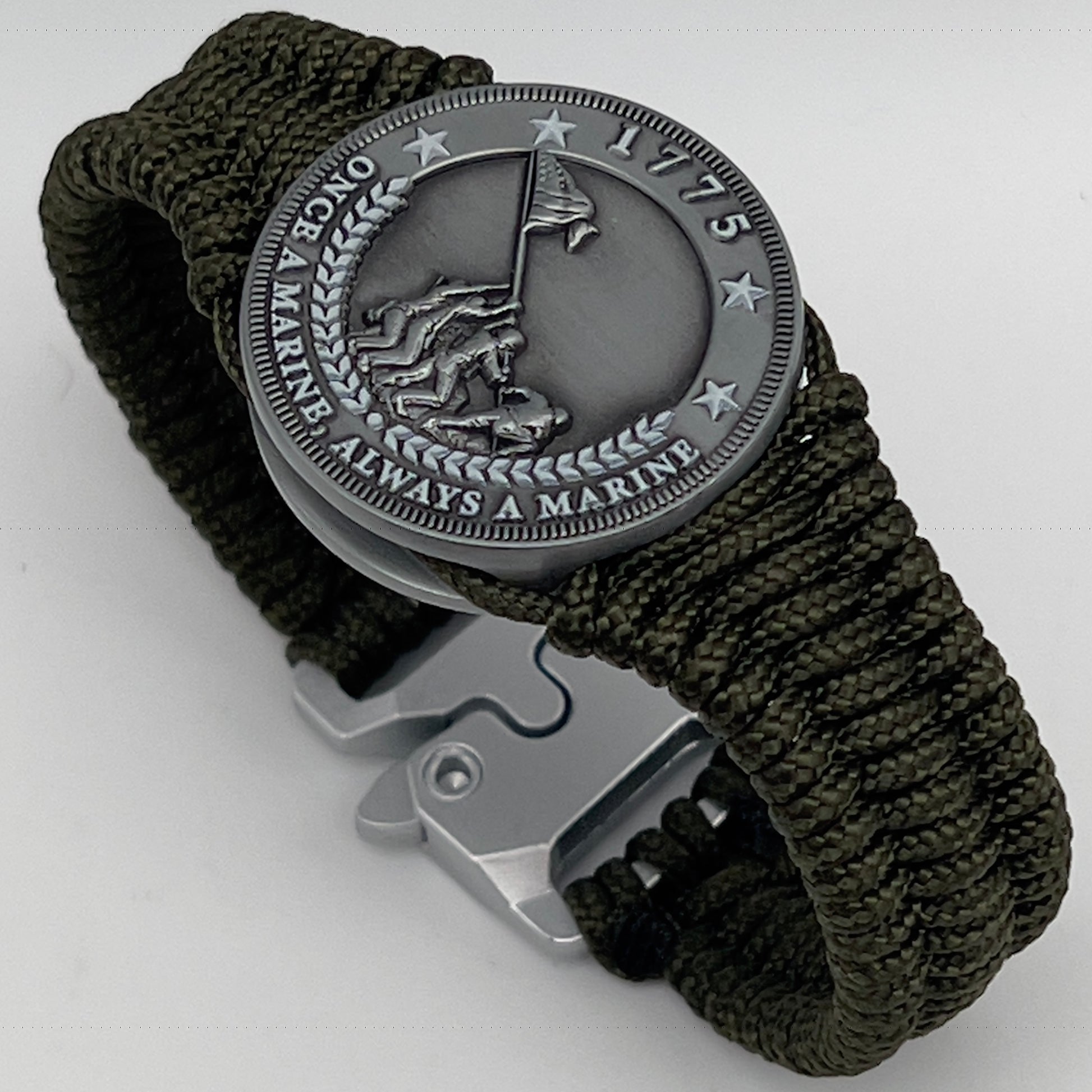 Thin, narrow, flexible and comfortable braided United States Marine Corps Iwo Jima bracelet featuring an antique silver plated UV painted Iwo Jima flag raising medallion, a silver Cobra style tactical buckle and woven with Olive Drab type-1 paracord.