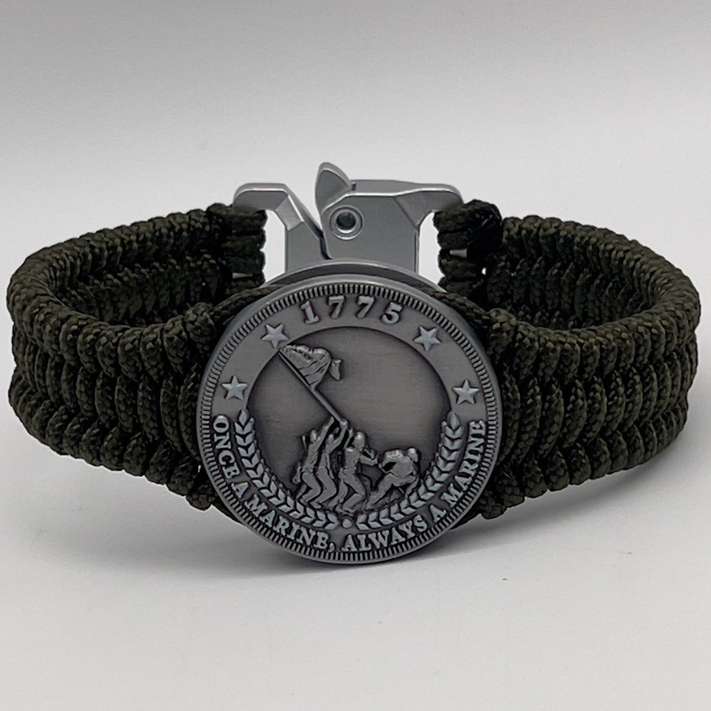 Thin, narrow, flexible and comfortable braided United States Marine Corps Iwo Jima bracelet featuring an antique silver plated UV painted Iwo Jima flag raising medallion, a silver Cobra style tactical buckle and woven with Olive Drab type-1 paracord.