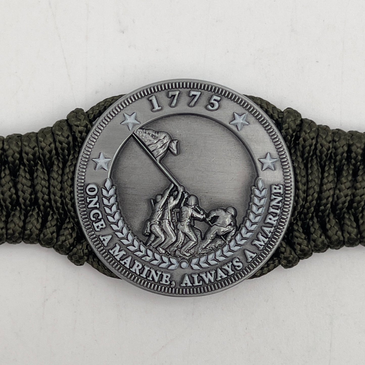 Thin, narrow, flexible and comfortable braided United States Marine Corps Iwo Jima bracelet featuring an antique silver plated UV painted Iwo Jima flag raising medallion, a silver Cobra style tactical buckle and woven with Olive Drab type-1 paracord.