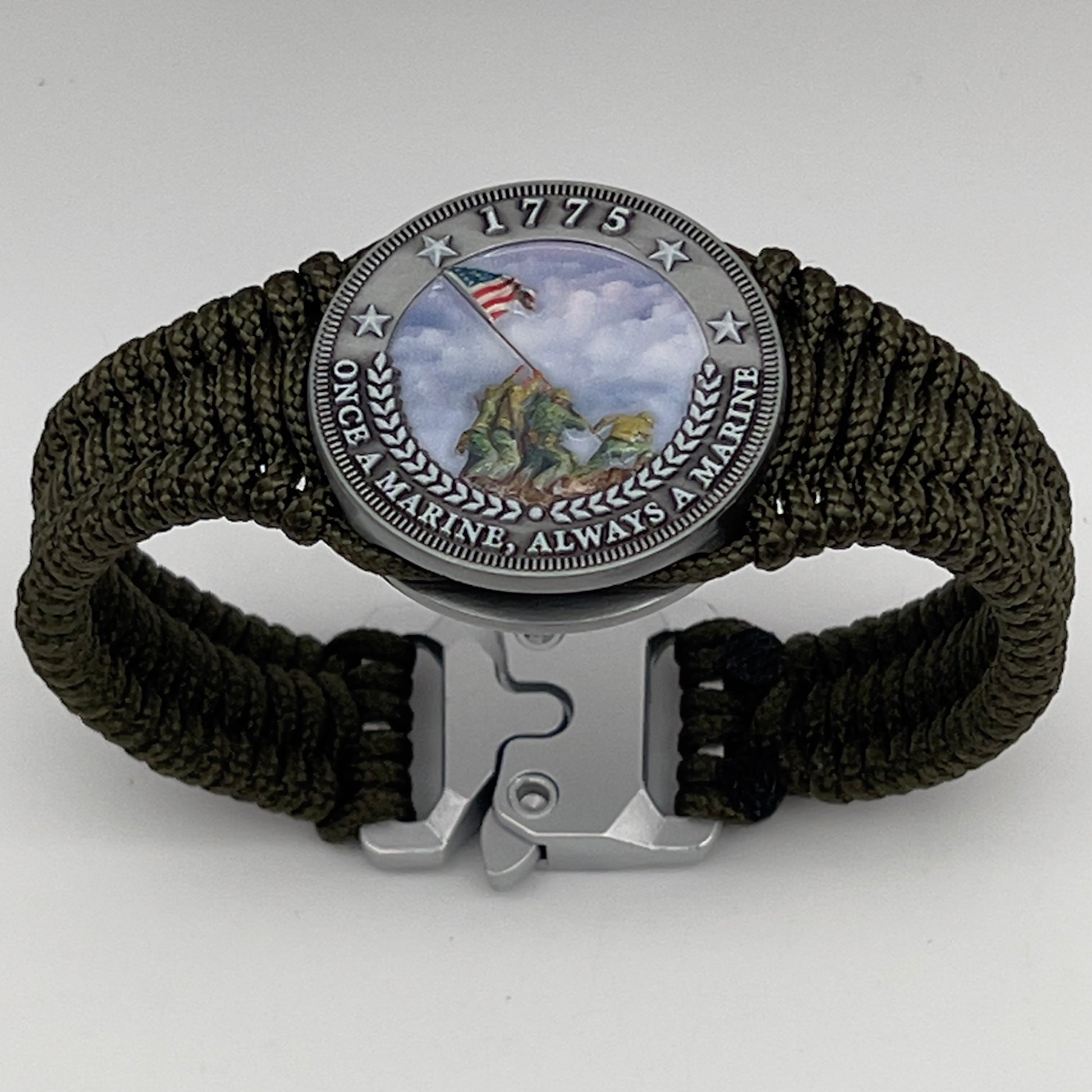 Thin, narrow, flexible and comfortable braided United States Marine Corps Iwo Jima bracelet featuring an antique silver plated UV painted Iwo Jima flag raising medallion, a silver Cobra style tactical buckle and woven with Olive Drab type-1 paracord.