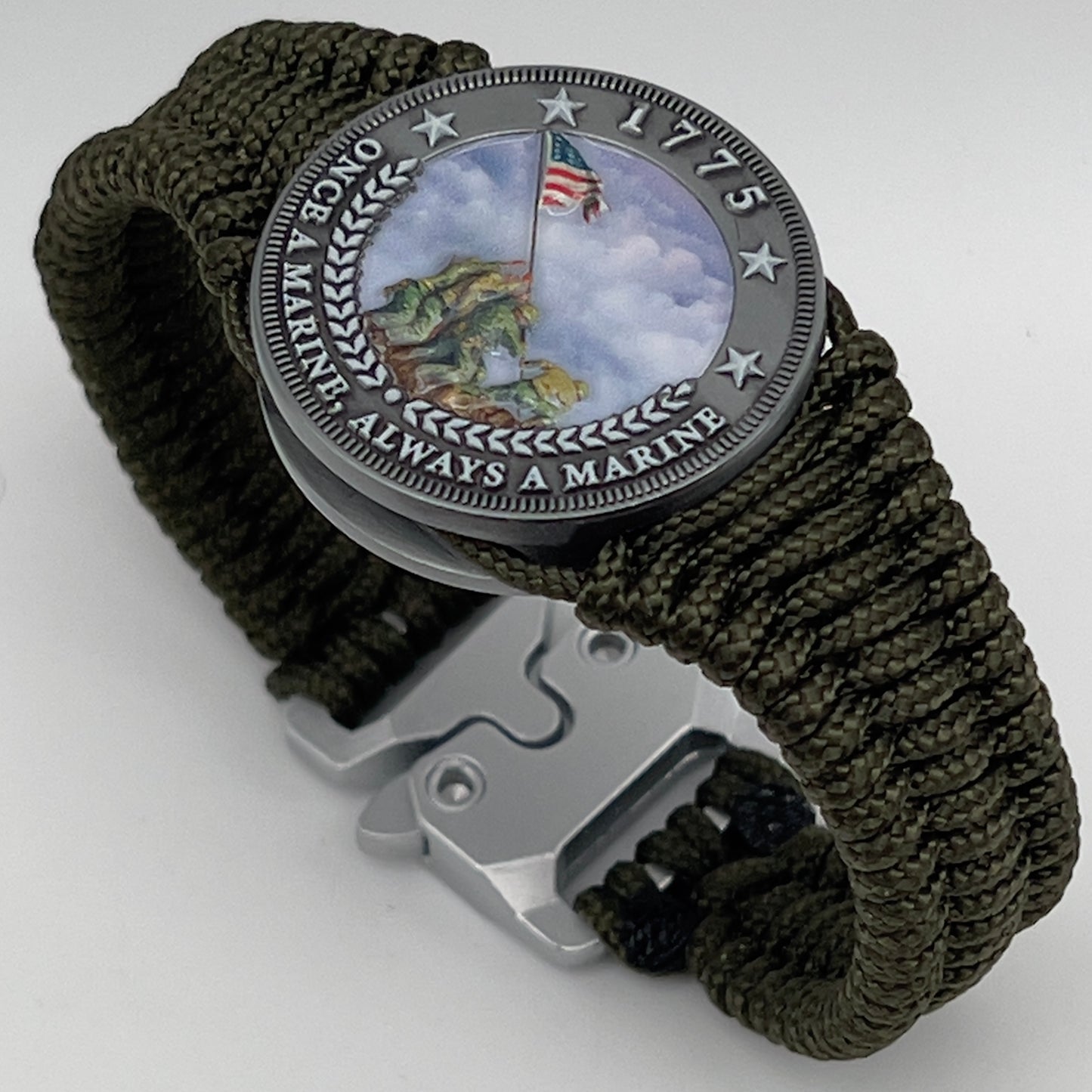 Thin, narrow, flexible and comfortable braided United States Marine Corps Iwo Jima bracelet featuring an antique silver plated UV painted Iwo Jima flag raising medallion, a silver Cobra style tactical buckle and woven with Olive Drab type-1 paracord.
