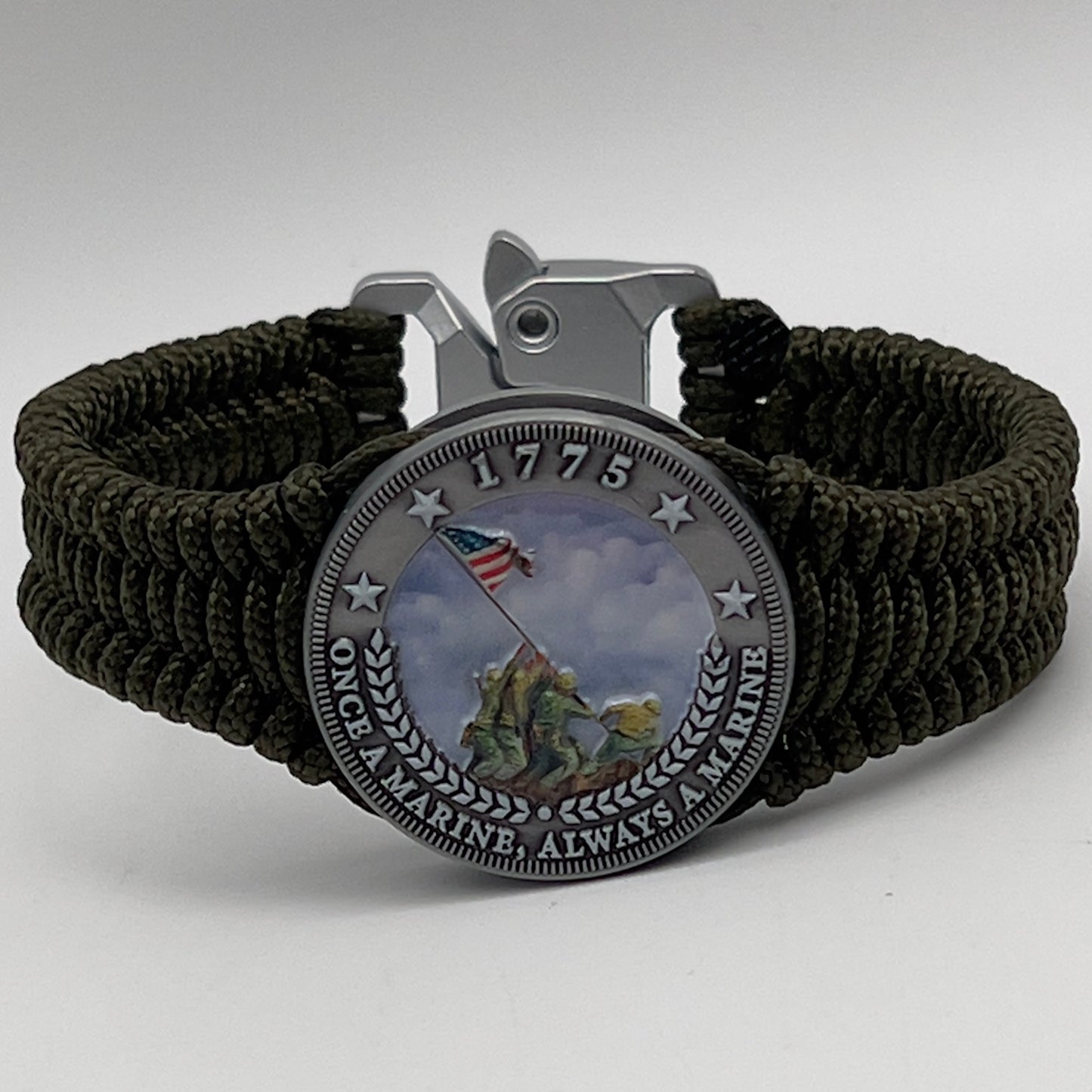 Thin, narrow, flexible and comfortable braided United States Marine Corps Iwo Jima bracelet featuring an antique silver plated UV painted Iwo Jima flag raising medallion, a silver Cobra style tactical buckle and woven with Olive Drab type-1 paracord.