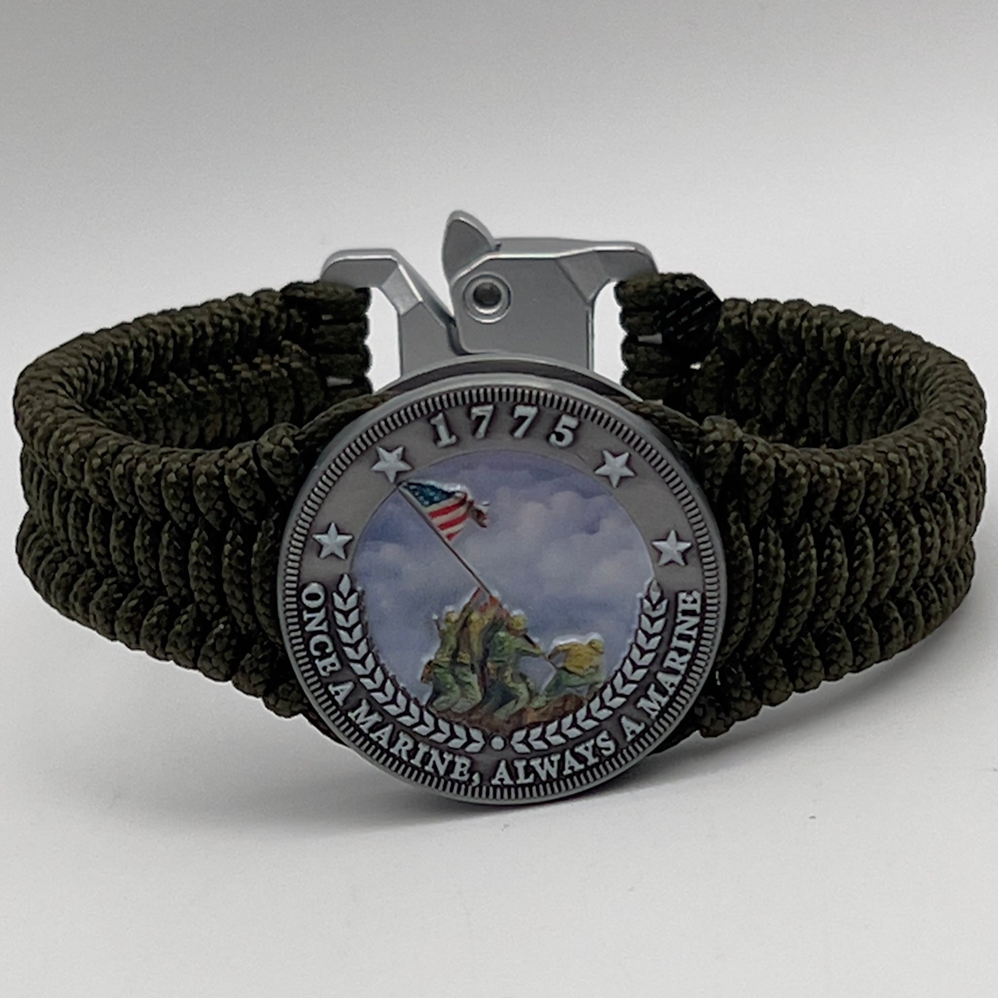 Thin, narrow, flexible and comfortable braided United States Marine Corps Iwo Jima bracelet featuring an antique silver plated UV painted Iwo Jima flag raising medallion, a silver Cobra style tactical buckle and woven with Olive Drab type-1 paracord.